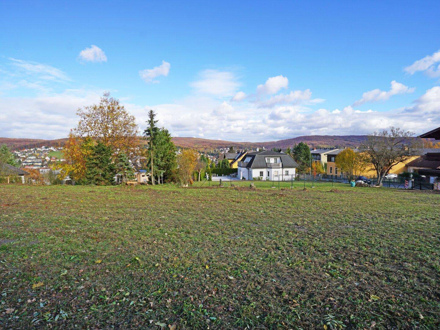 Offenes Grundstück mit Panoramablick auf die hügelige Landschaft und eine malerische Siedlung.