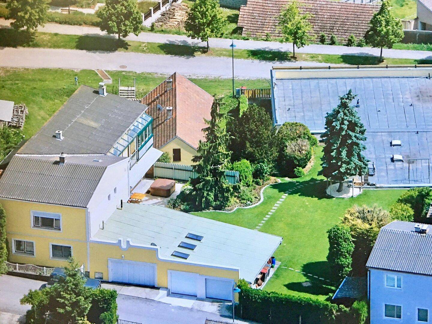 Luftaufnahme des Anwesens mit großem Garten, Wohnhaus und Nebengebäuden in ländlicher Umgebung.