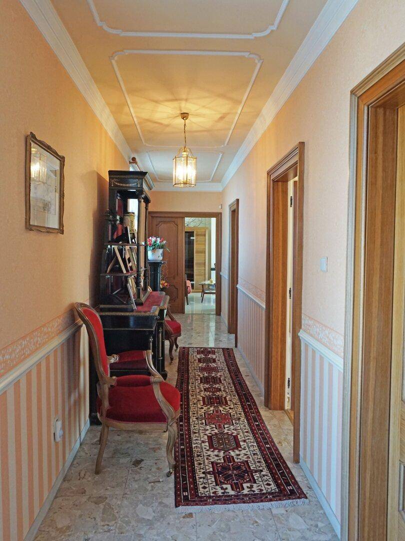 Heller Flur mit Marmorboden, dekorativer Decke und traditionellen Möbeln.