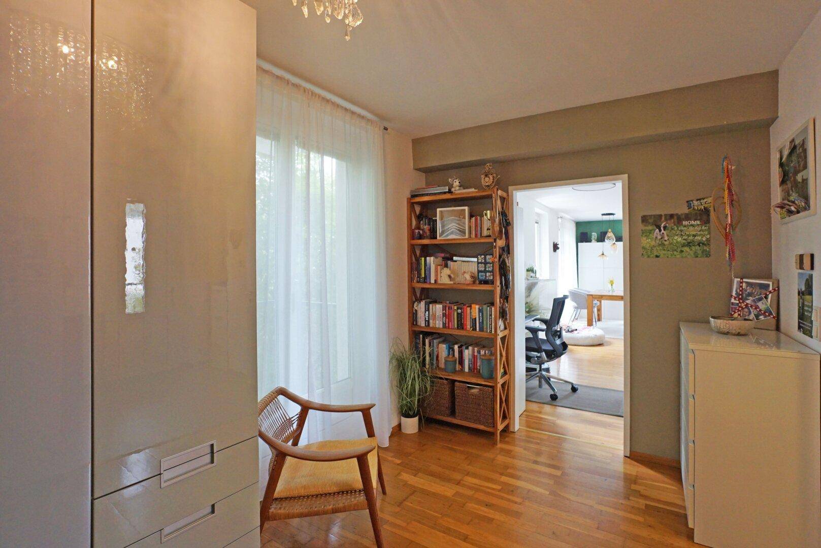 Heller Flur mit Holzfußboden, Einbauschrank und Blick in den angrenzenden Wohnbereich.