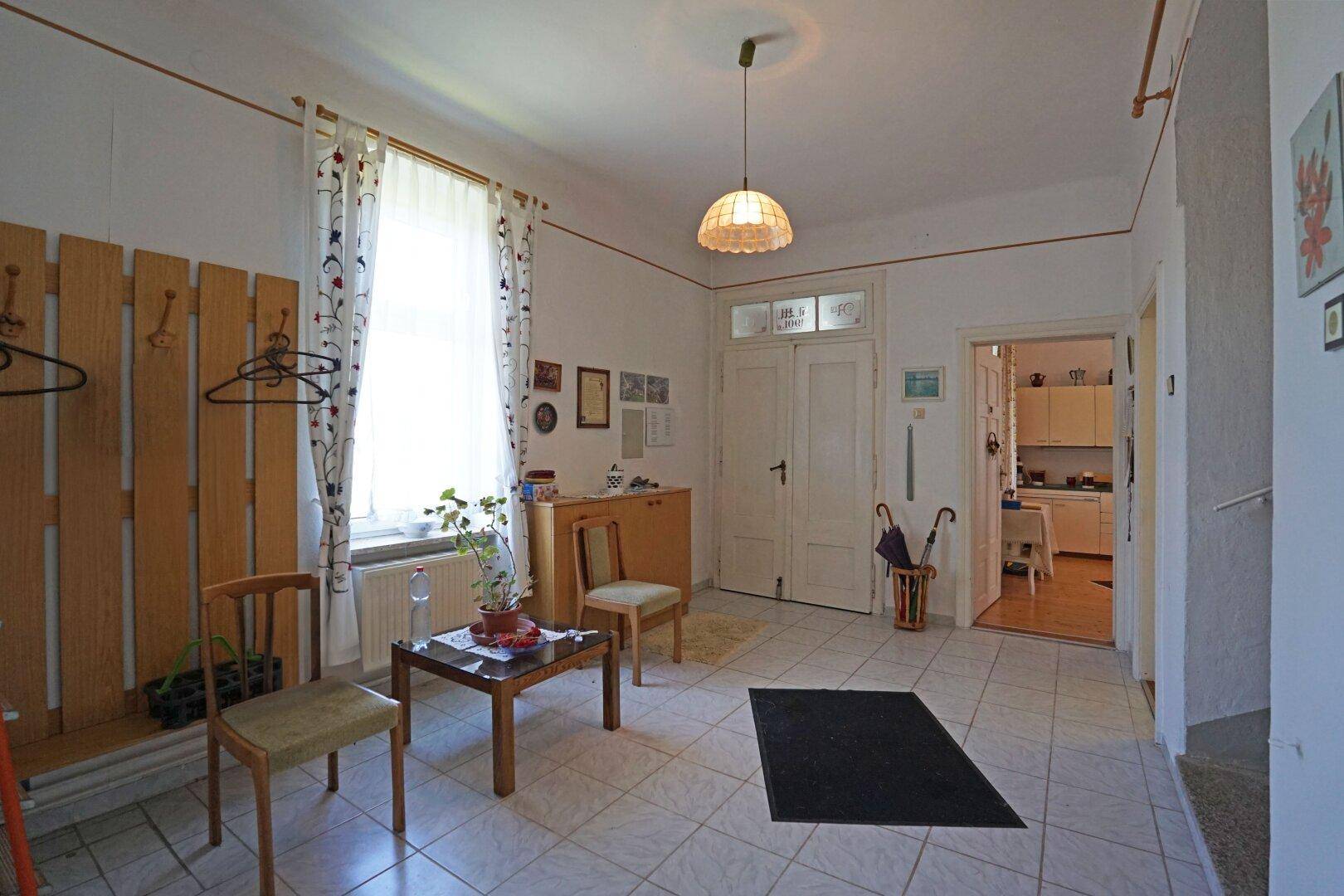 Heller Eingangsbereich mit Fliesenboden, Garderobe und Zugang zu weiteren Räumen.