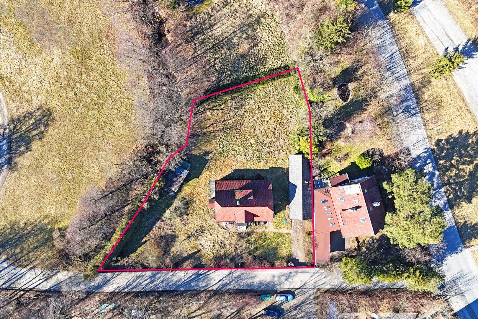 Luftaufnahme des Anwesens mit Grundstücksgrenzen, umgeben von Feldern und einer Zufahrtsstraße.