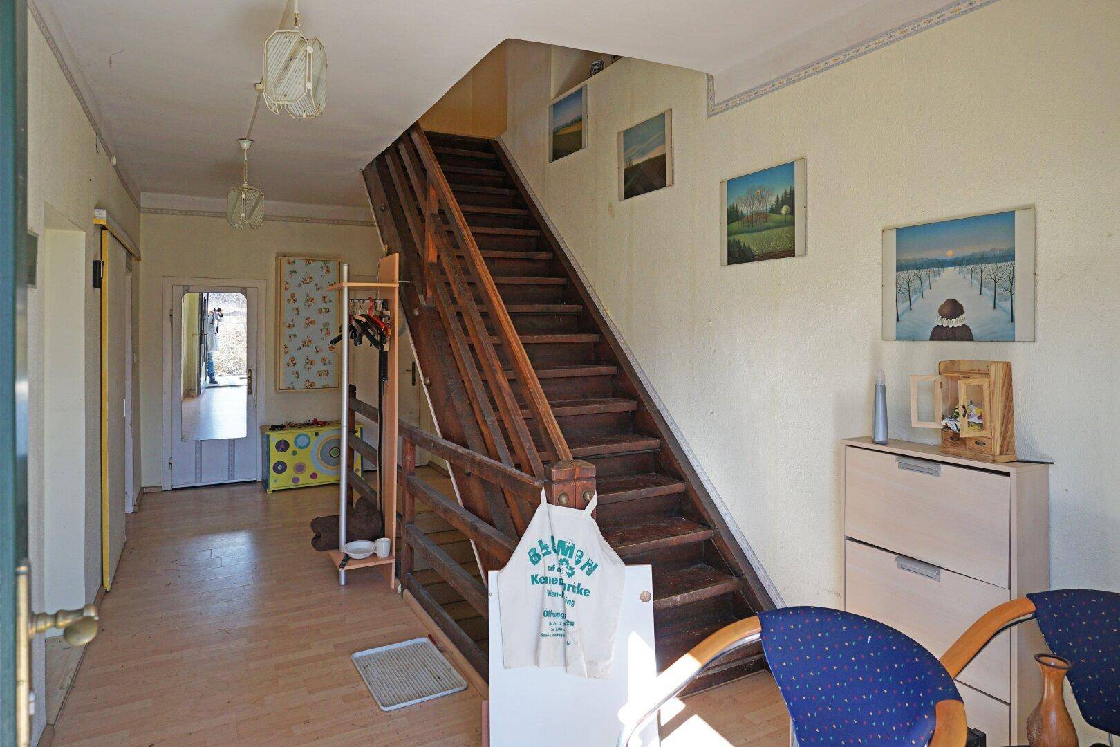 Geräumiger Flur mit Holztreppe, hellem Laminatboden und traditioneller Einrichtung im Eingangsbereich.