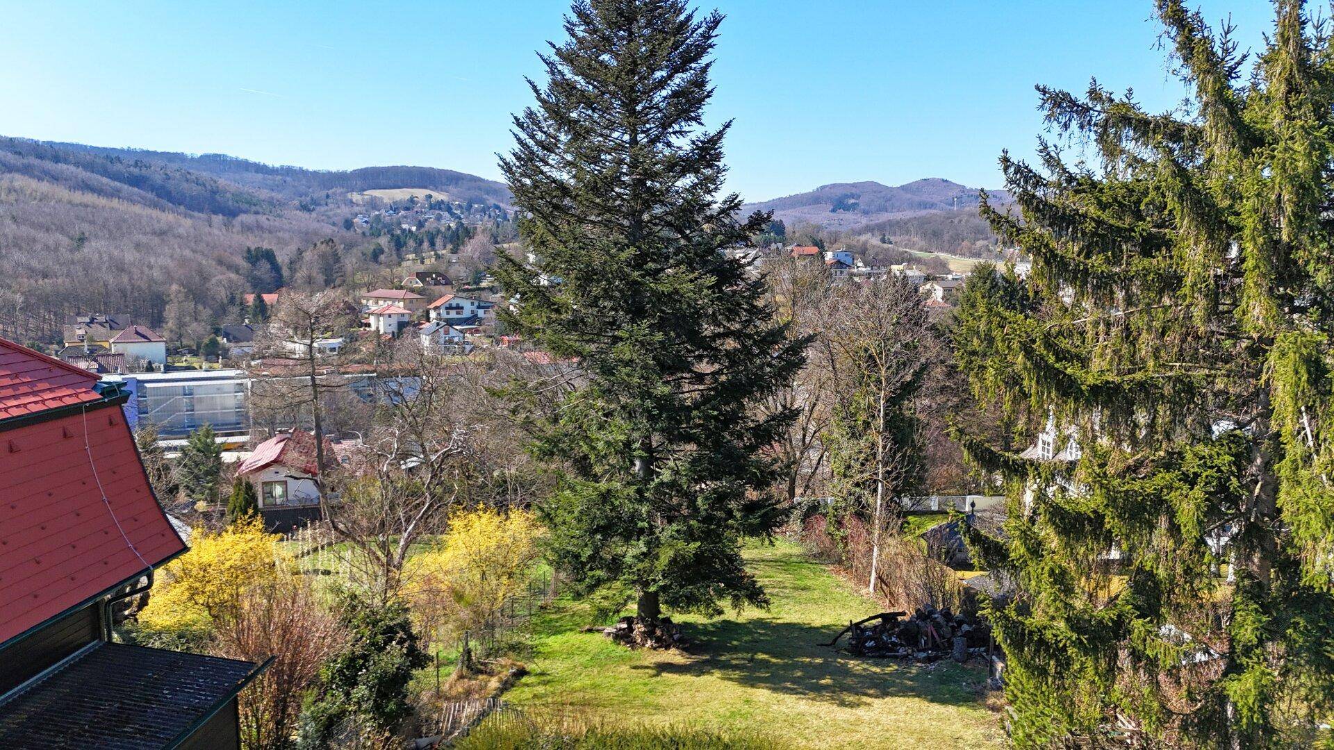 Gartenbereich mit weitem Blick über die umliegende Landschaft und die Dächer der Häuser.