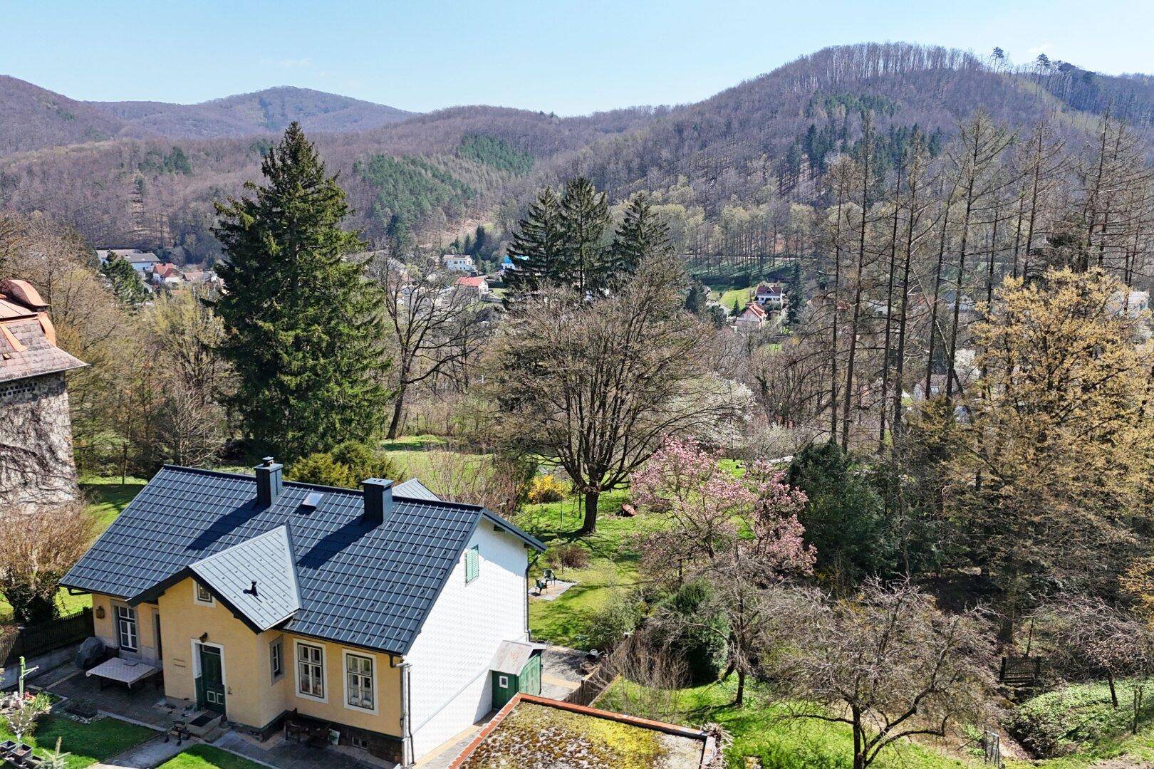 Weitläufige Luftaufnahme des Anwesens mit Blick auf die umliegende Hügellandschaft und Wälder.