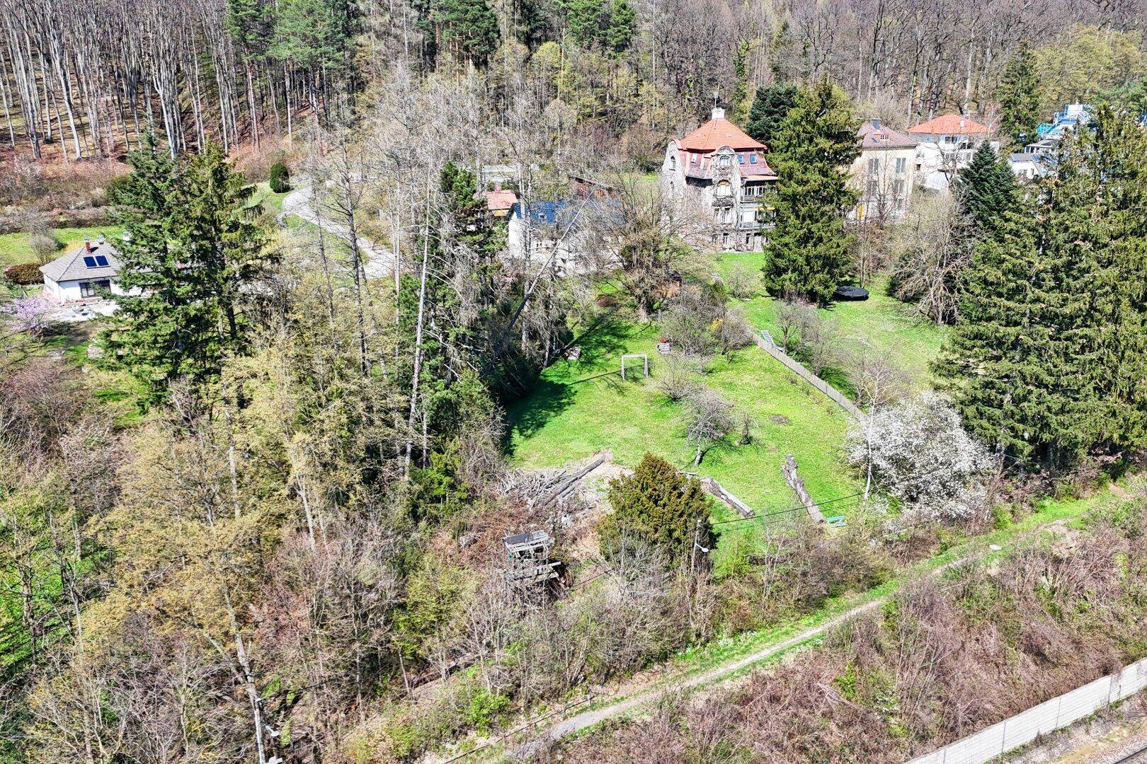 Weitläufiges Anwesen aus der Vogelperspektive, eingebettet in eine grüne Waldlandschaft.