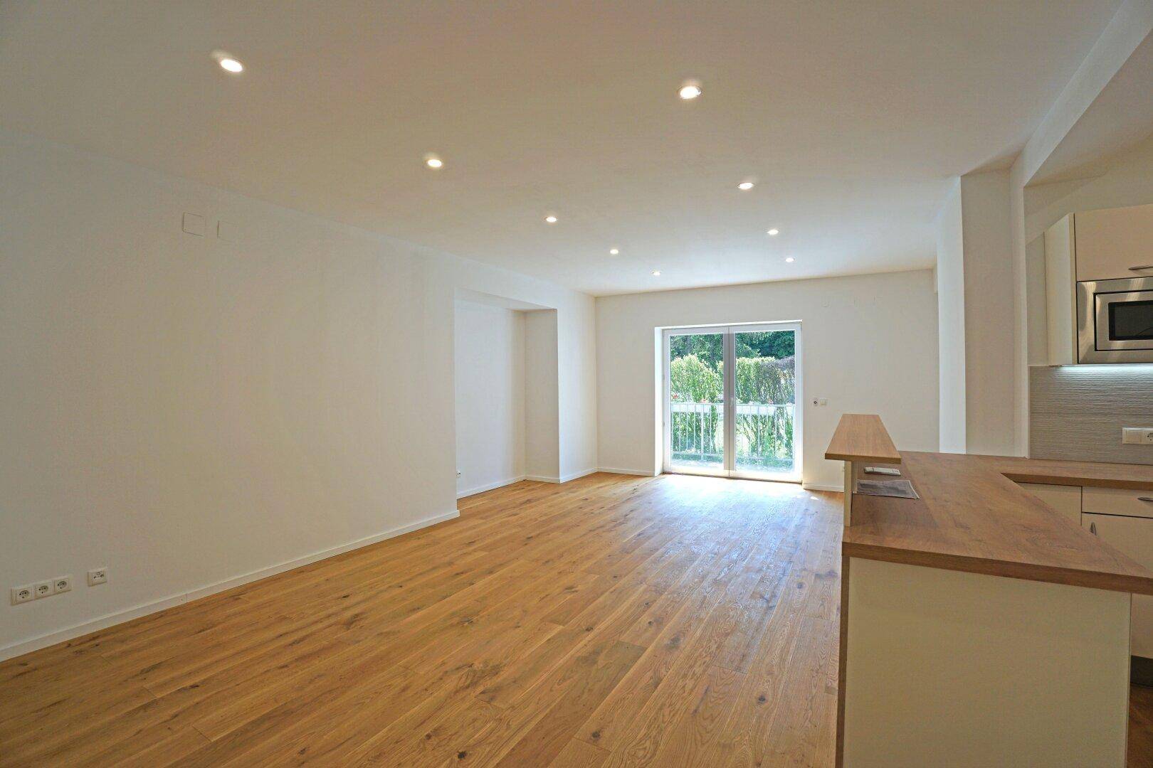 Wohnzimmer mit offener Küche und Terrassenausgang