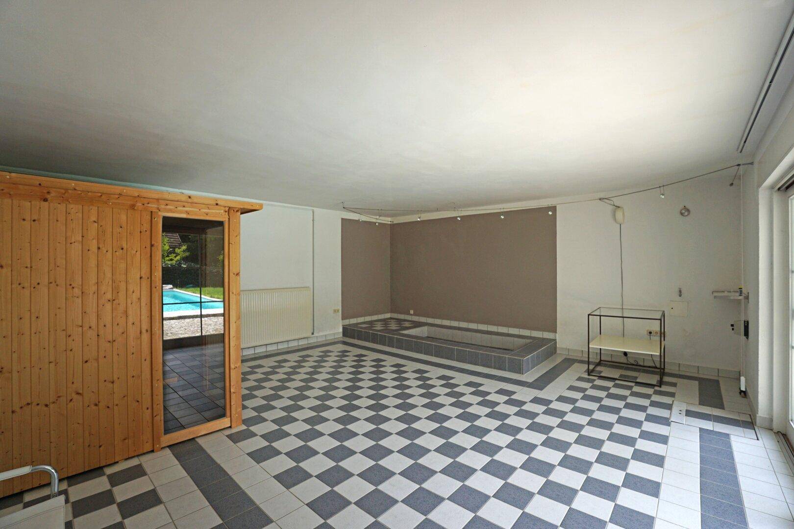 Wellness-/Fitness-Bereich mit Sauna, Tauchbecken und Ausgang zum Pool