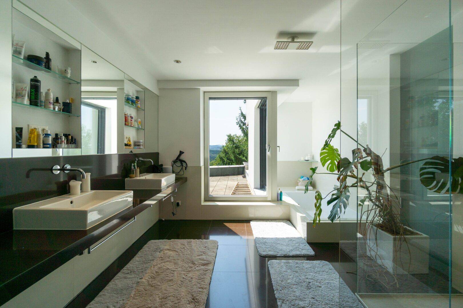 Modernes Badezimmer mit Doppelwaschbecken, großer Dusche und Zugang zur Dachterrasse.