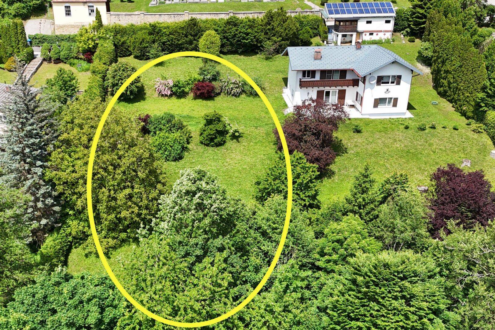 Luftaufnahme eines Grundstücks mit Wohnhaus, Garten und umliegender grüner Landschaft.