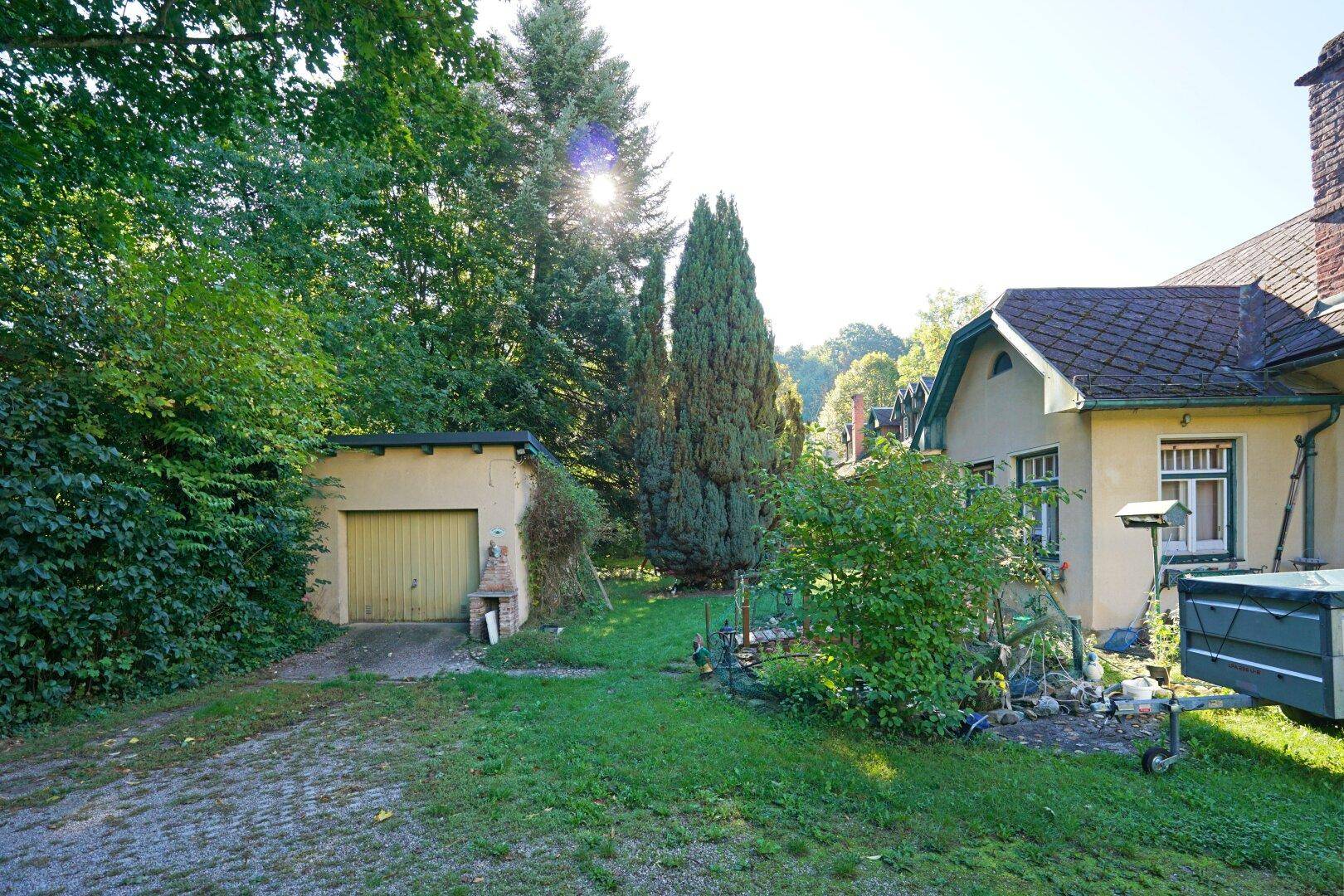 Seitlicher Blick auf das Haus mit einer separaten Garage und einem gepflegten Gartenbereich.