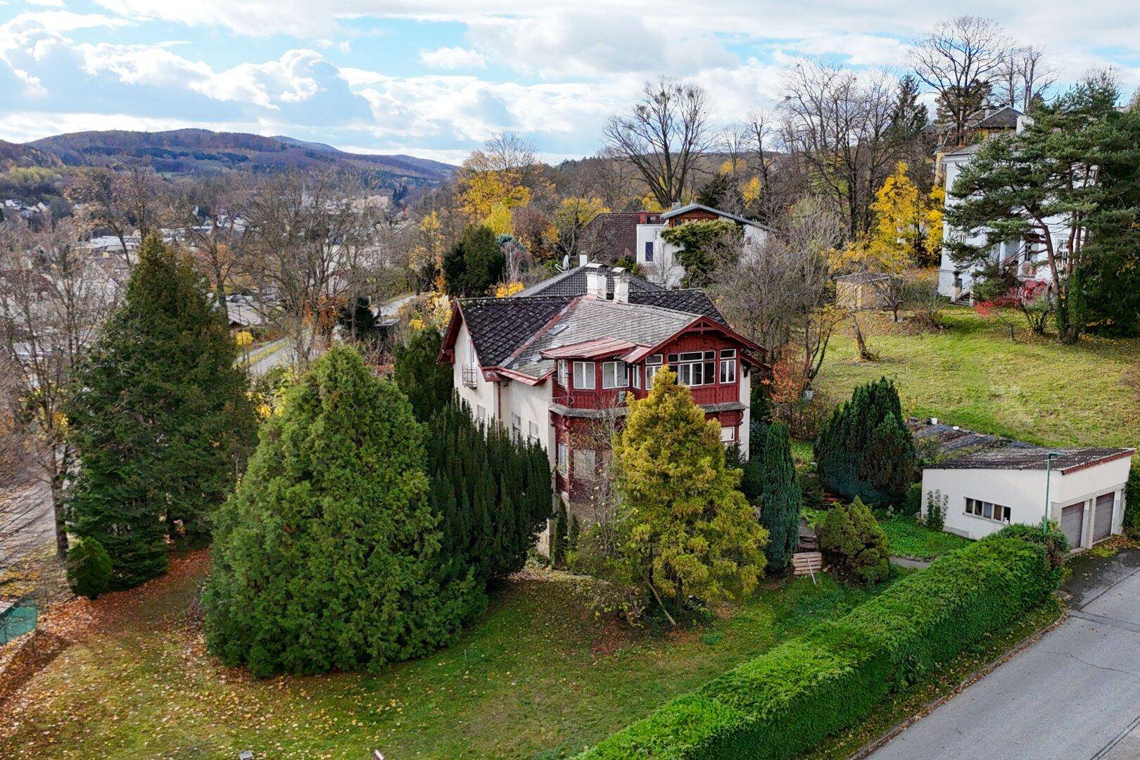 Historische Villa mit weitläufigem Grundstück und Blick auf die umliegende Landschaft im Herbst.