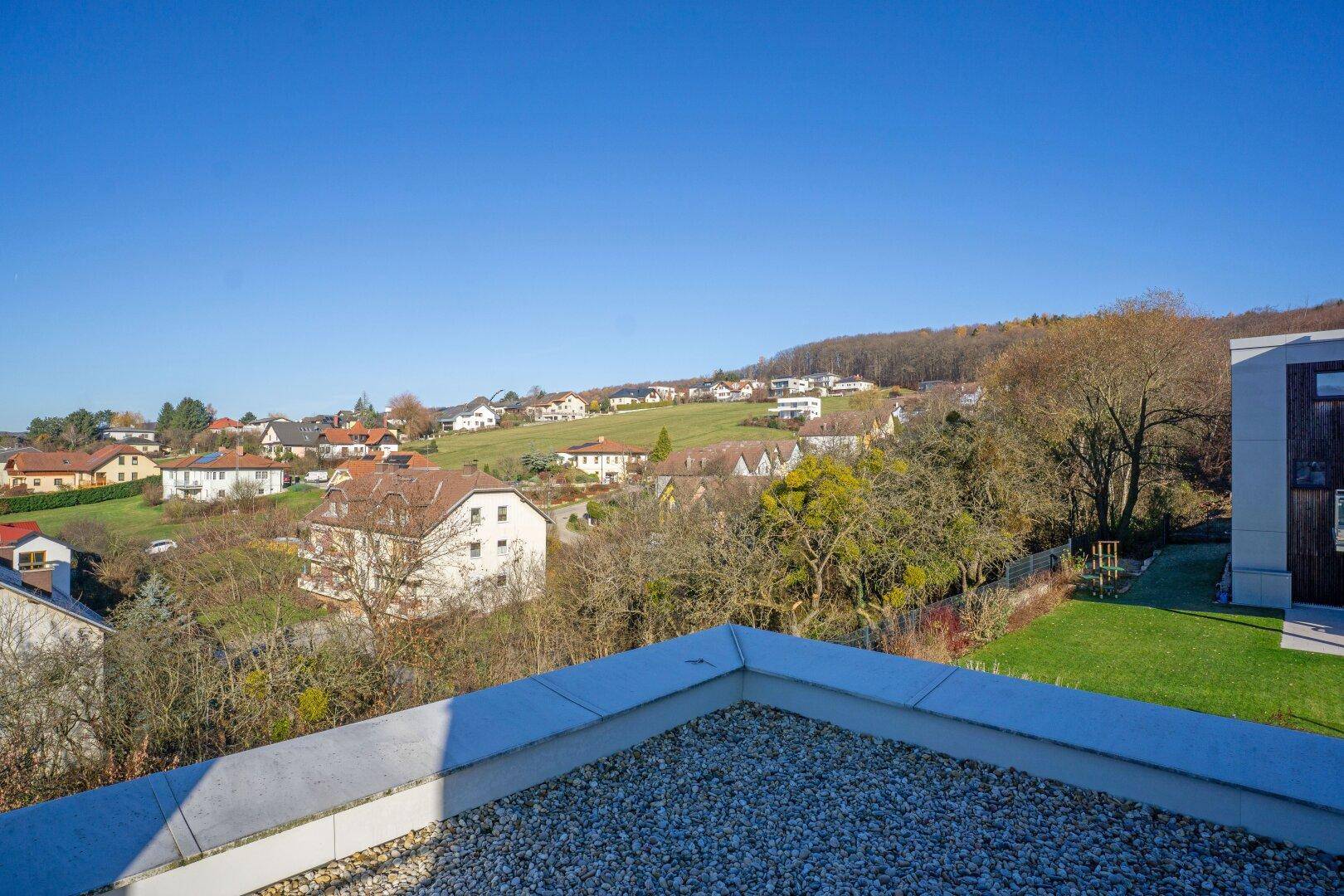 Weitläufiger Blick auf die grüne Hügellandschaft und die verstreute Bebauung.