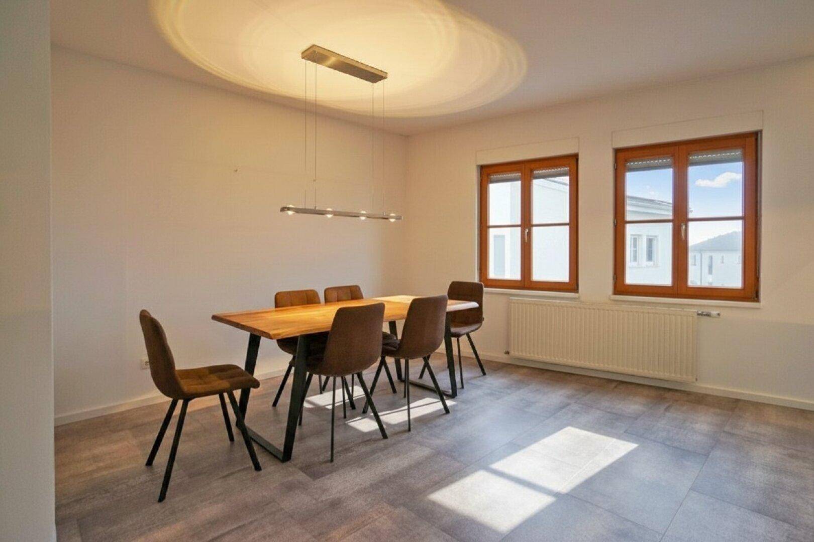 Heller Essbereich mit Holztisch, modernen Stühlen und großen Fenstern für viel Licht.