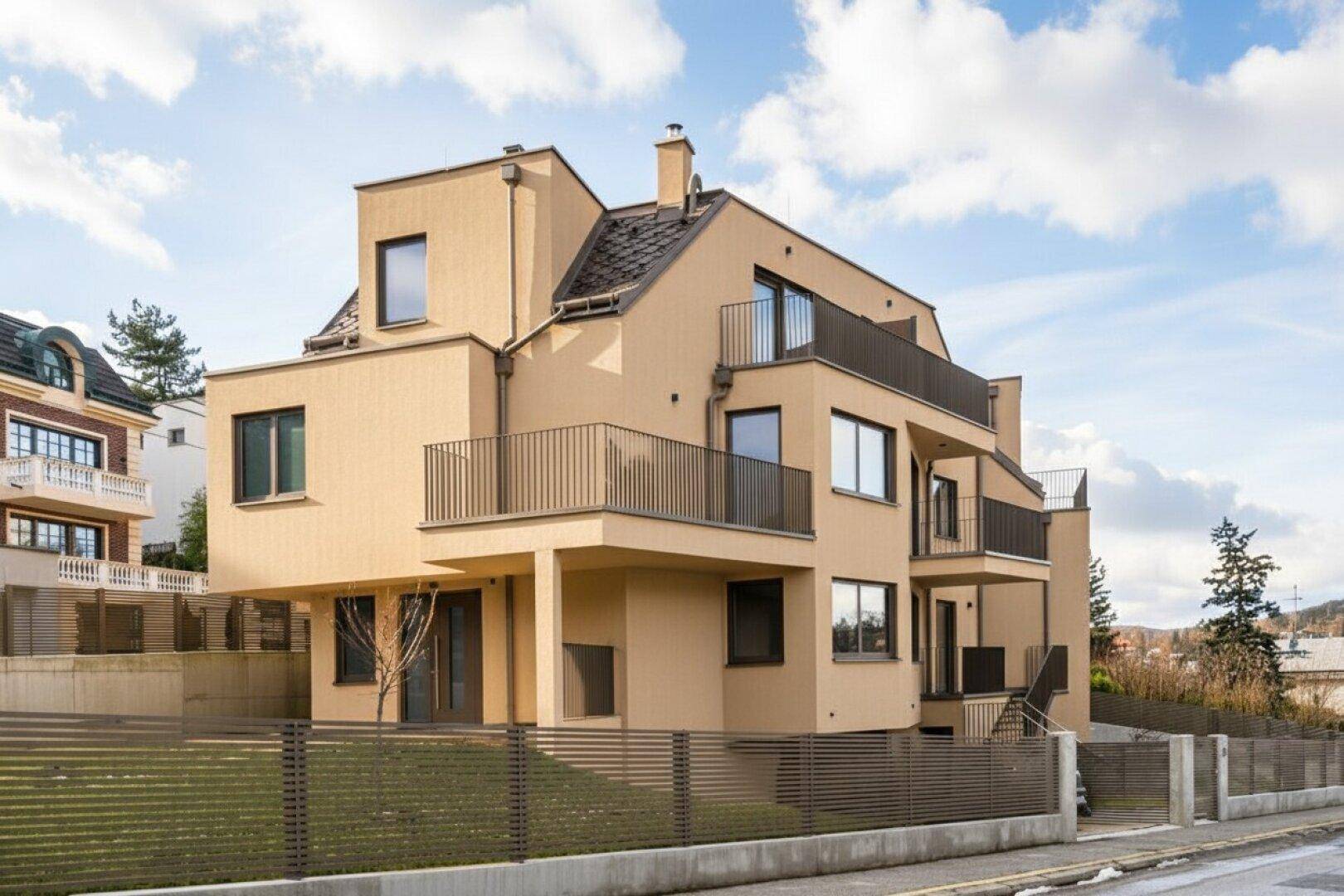 Ansicht des modernen Wohnhauses von der Straßenseite mit mehreren Balkonen und eleganter Architektur.