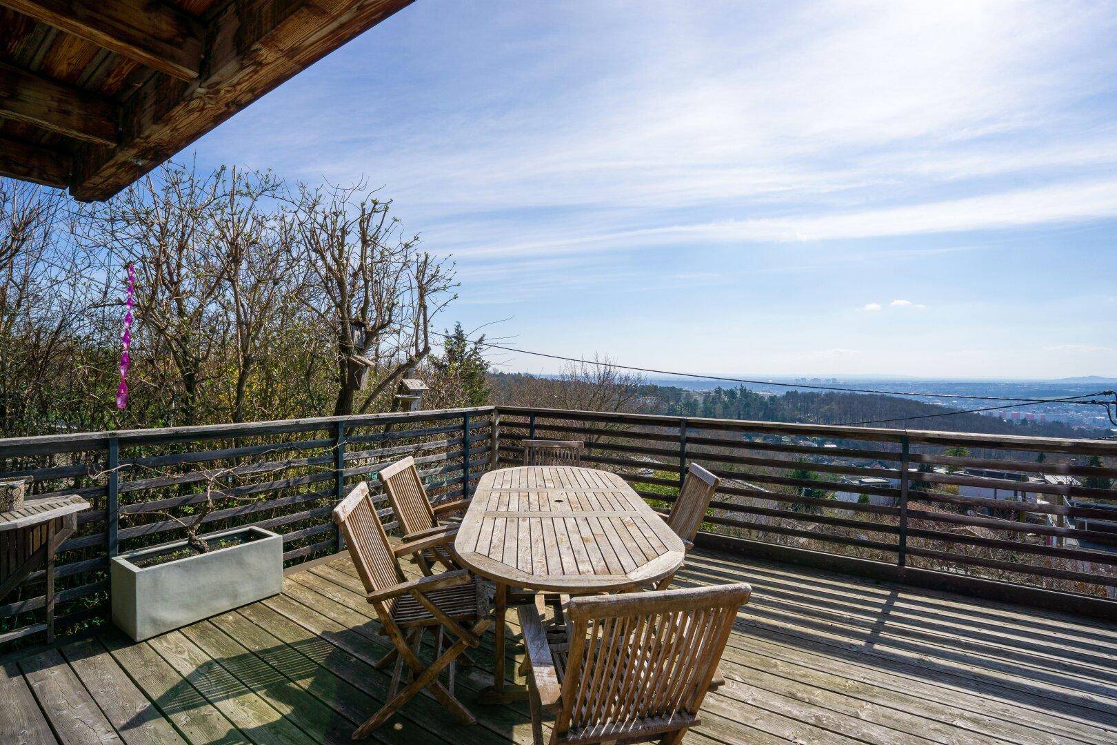 Sonniger Terrassenbereich mit Holzboden und Sitzgelegenheiten, ideal für entspannte Stunden im Freien.