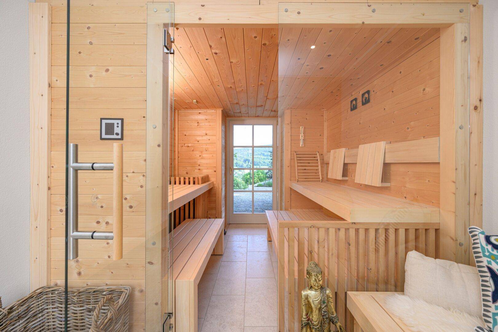 Private Holzsauna mit Bänken und Blick ins Grüne, ideal zur Entspannung und Erholung.