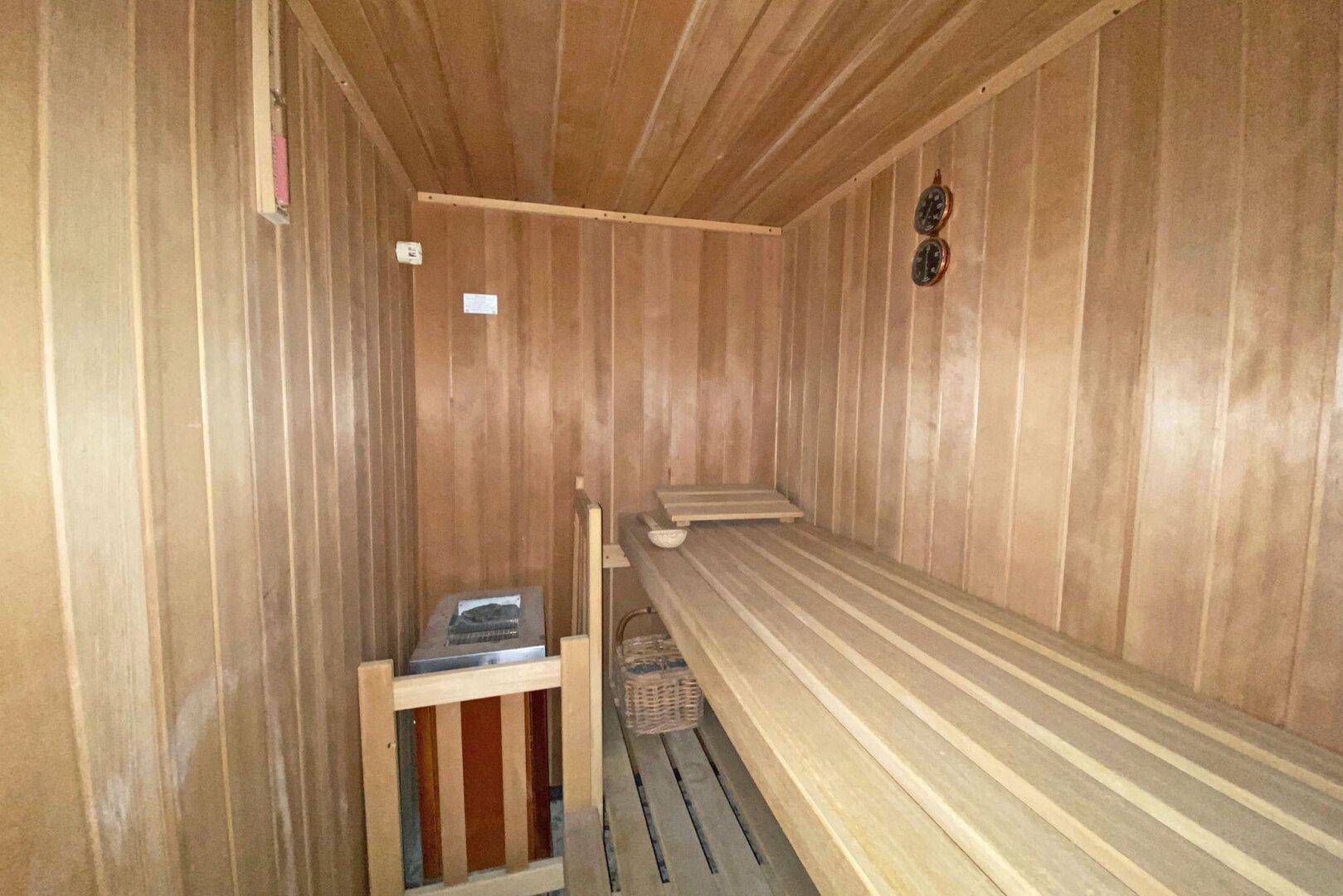 Gemütliche Holzsauna mit Bänken und Saunaofen für entspannende Momente.