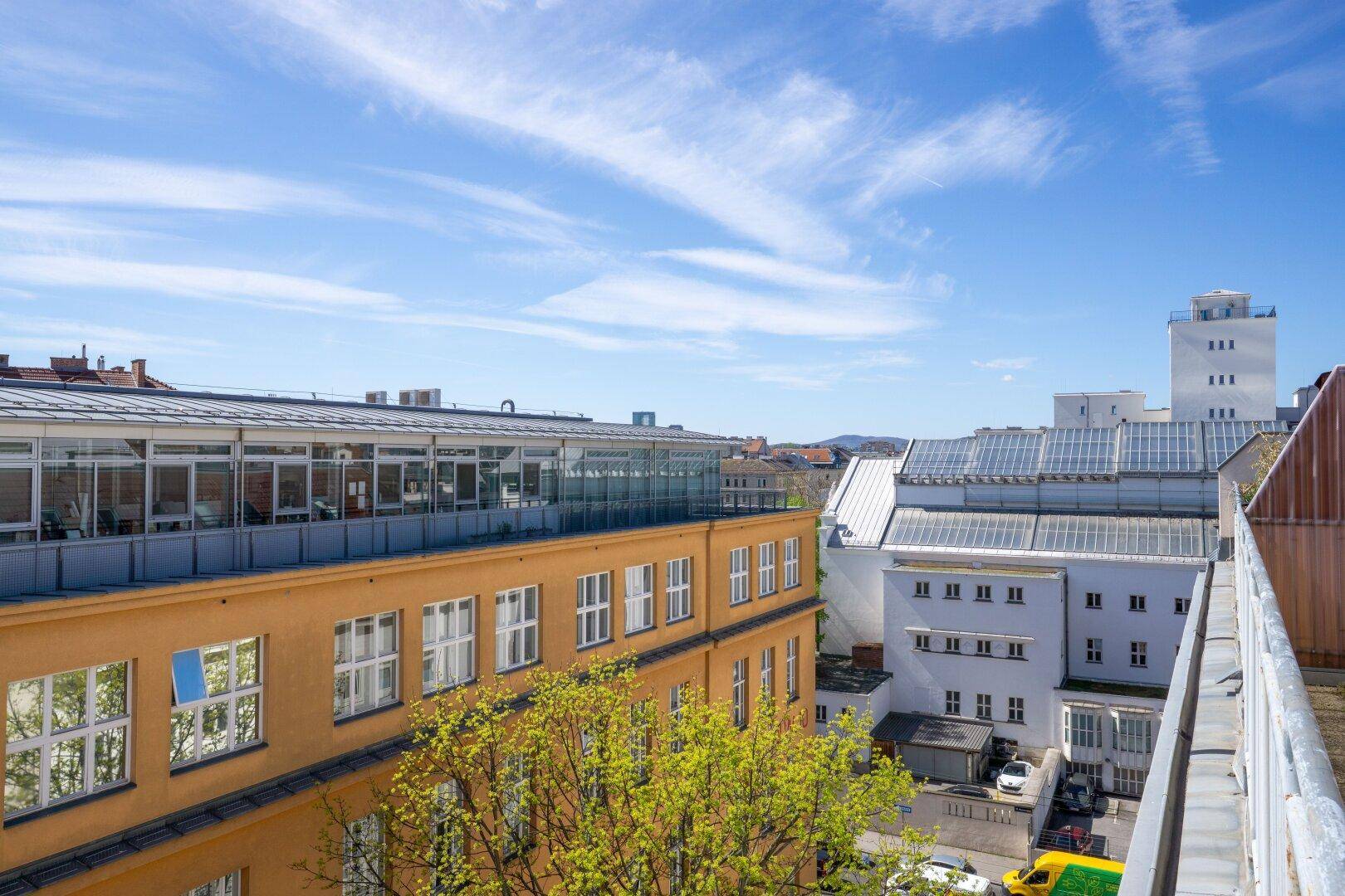 Panoramablick über die städtische Umgebung mit verschiedenen Gebäuden und einem blauen Himmel.