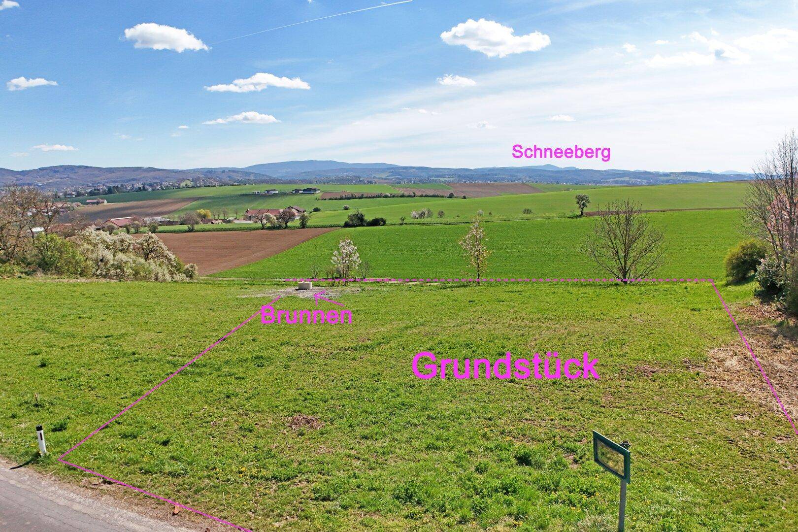 Luftaufnahme eines grünen Grundstücks mit Blick auf die umliegende Landschaft und den Schneeberg.