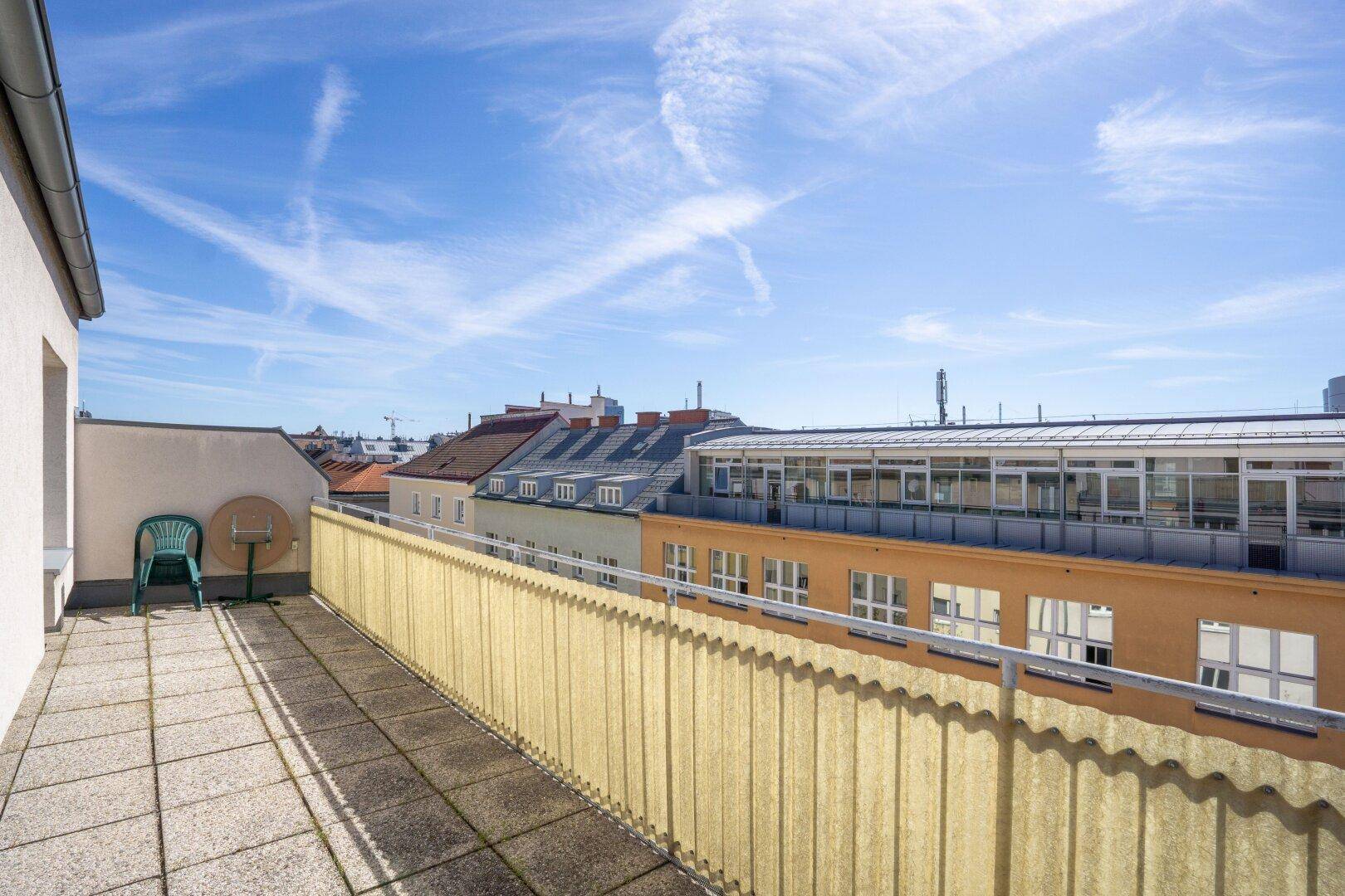 Sonniger Terrassenbereich mit Fliesenboden und einfacher Bestuhlung, ideal zum Entspannen im Freien.