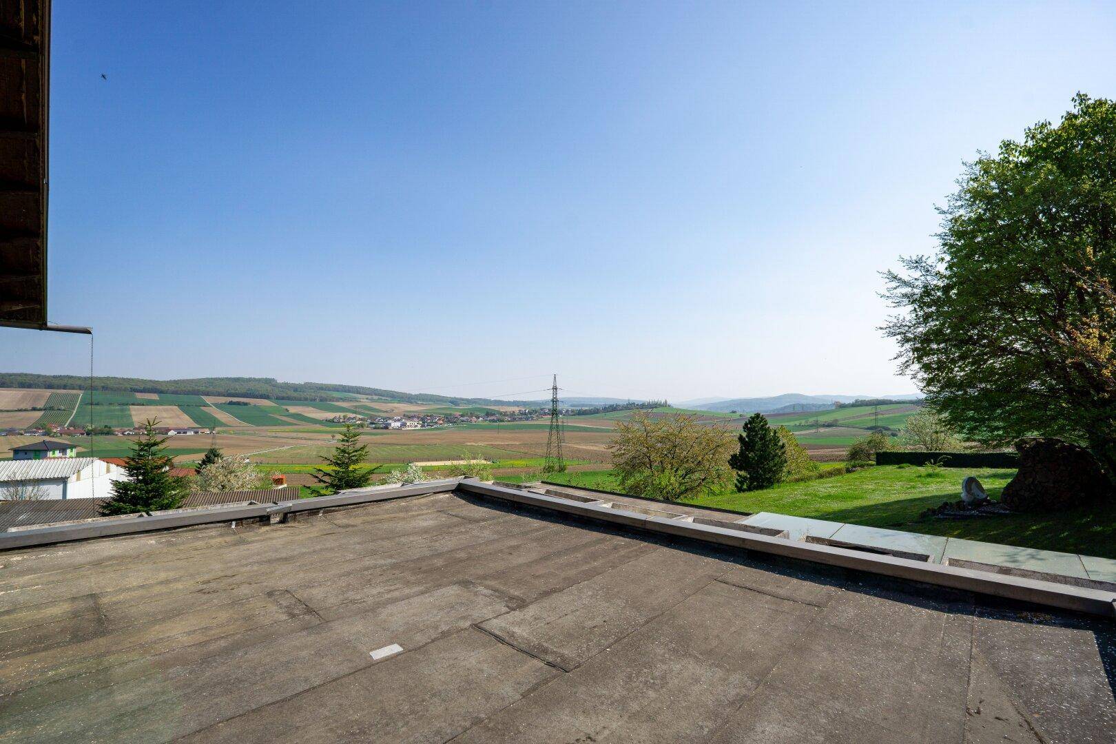 Weitläufiger Ausblick von der Dachterrasse über die Felder und die hügelige Landschaft.