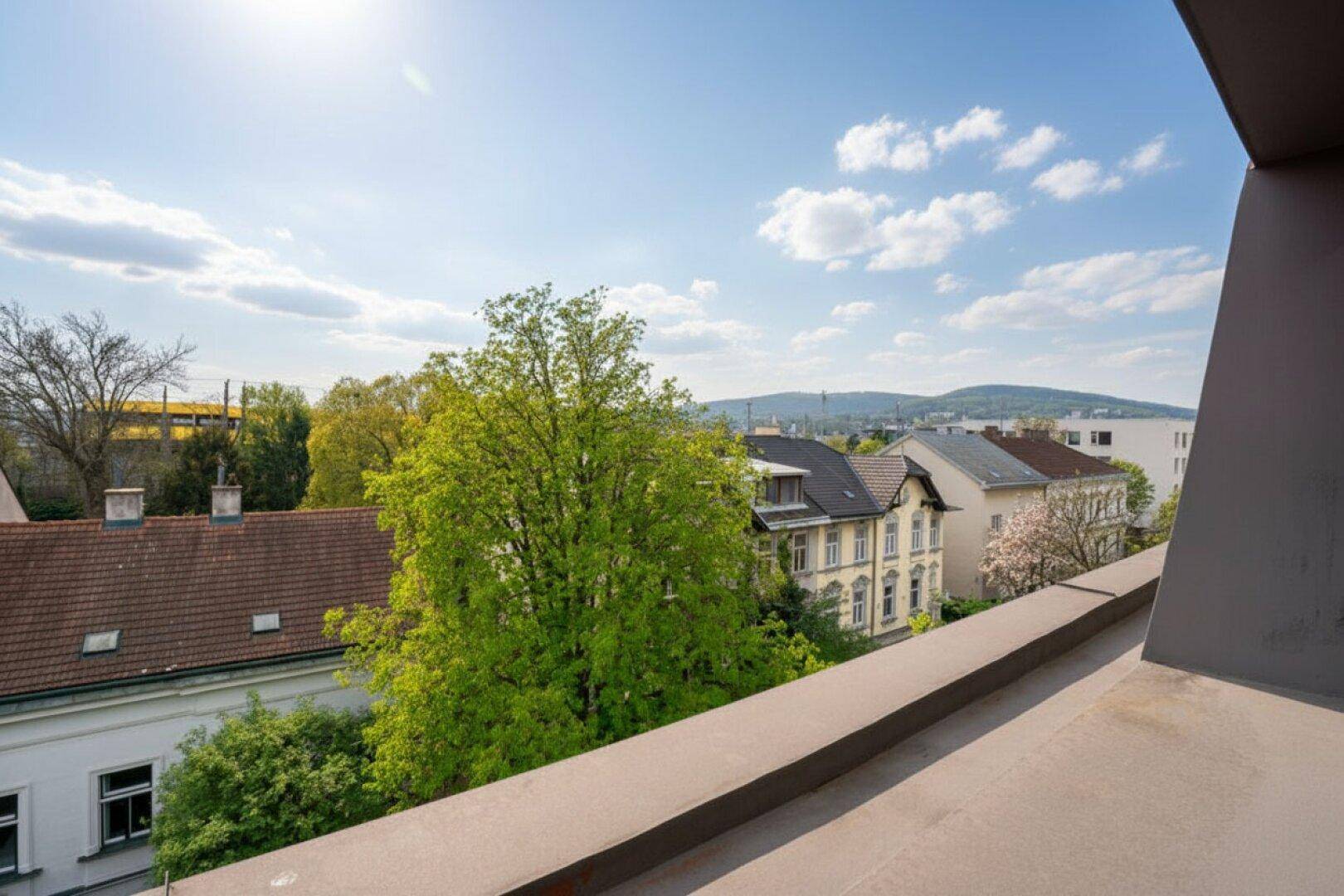 Panoramablick über die Stadt und die umliegende Landschaft unter blauem Himmel.
