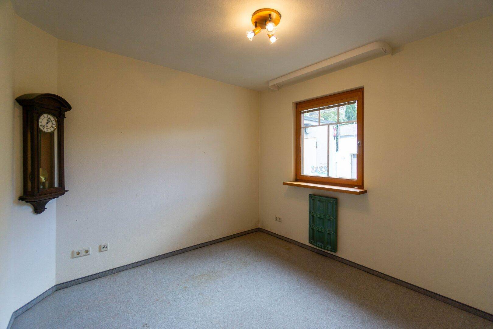 Helles Zimmer mit Teppichboden und Fenster, ideal als Schlaf- oder Arbeitszimmer.
