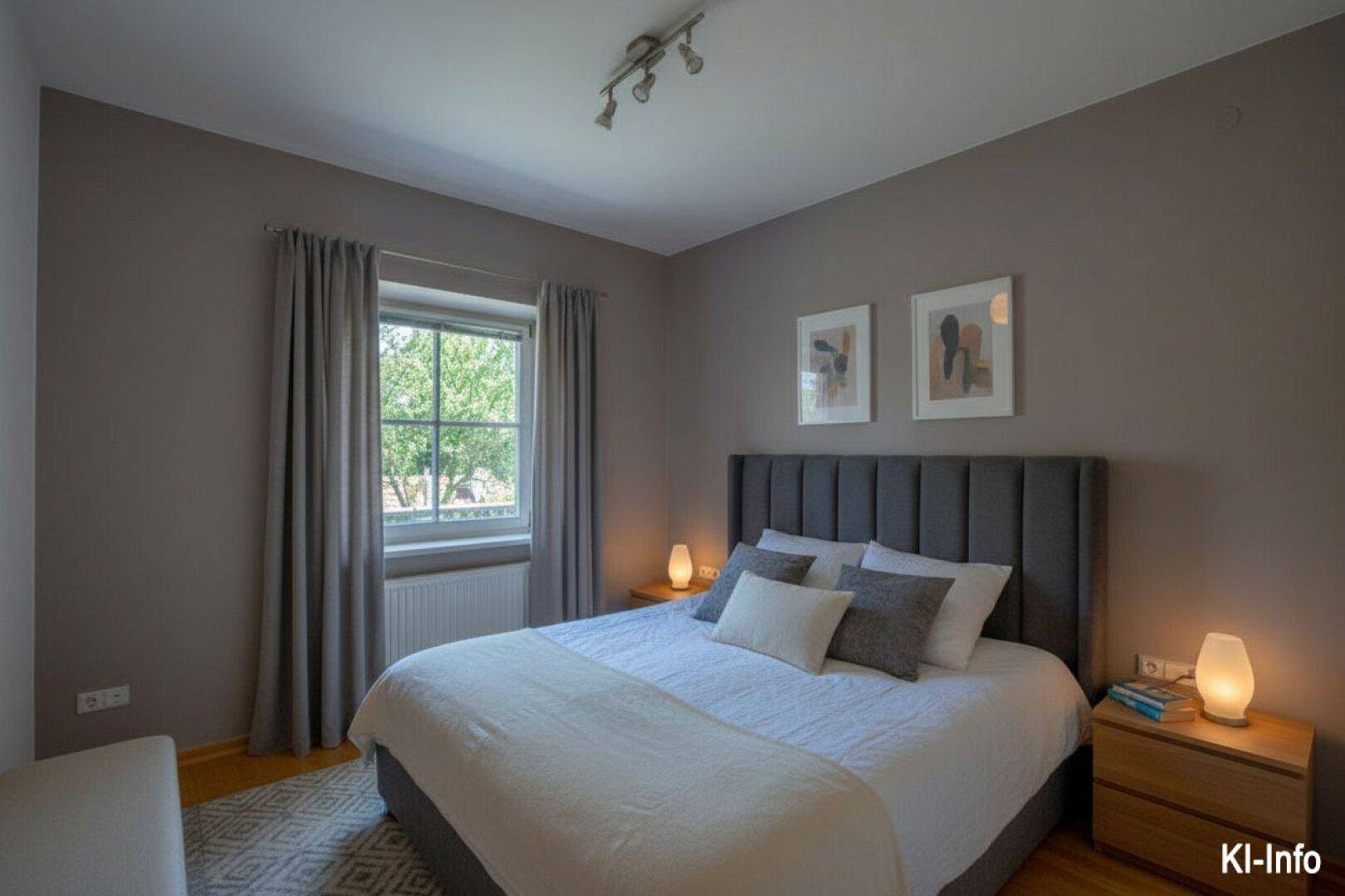 Modern eingerichtetes Schlafzimmer mit Doppelbett, grauen Wänden und Holzfußboden.