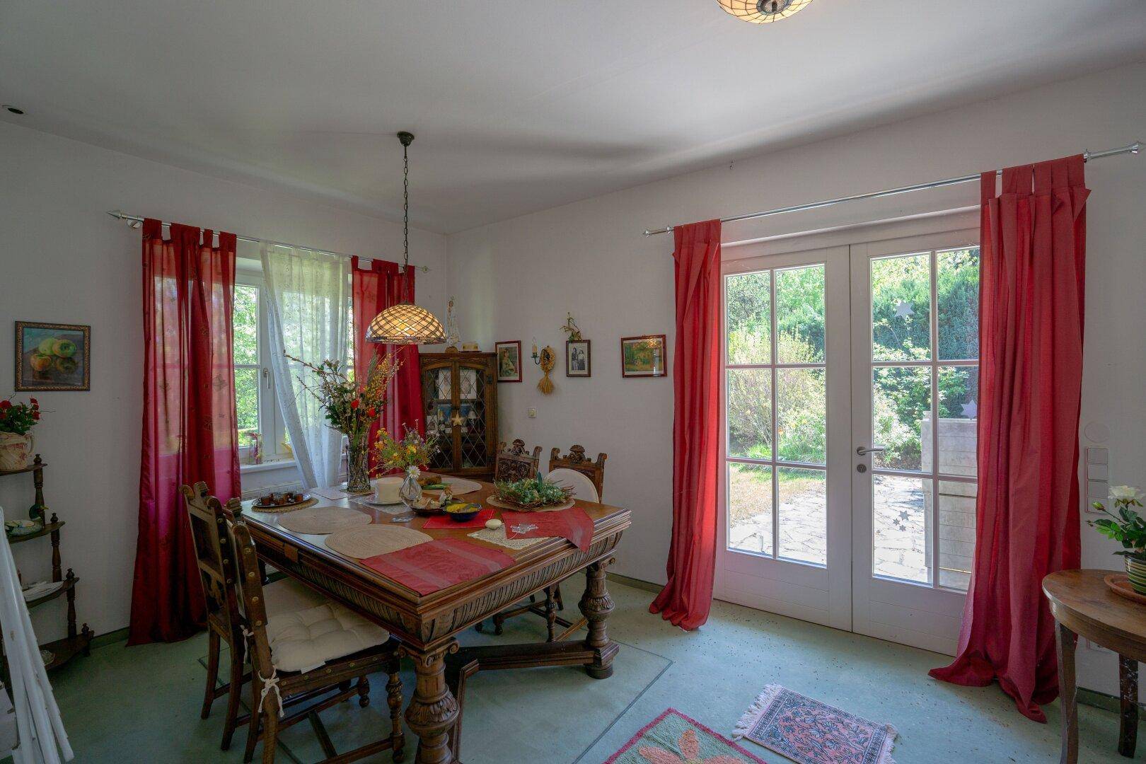 Traditionell eingerichtetes Esszimmer mit Holztisch und direktem Zugang zum Garten.