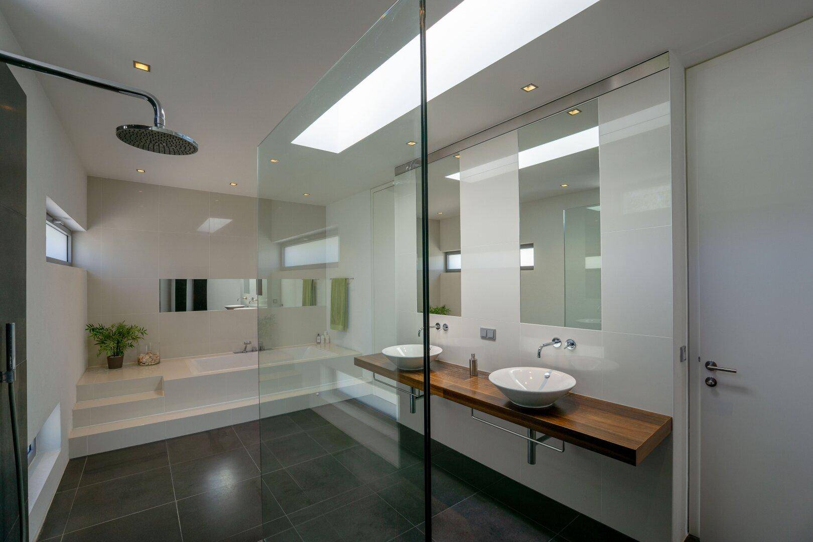 Modernes Badezimmer mit Doppelwaschbecken, begehbarer Dusche und Badewanne.