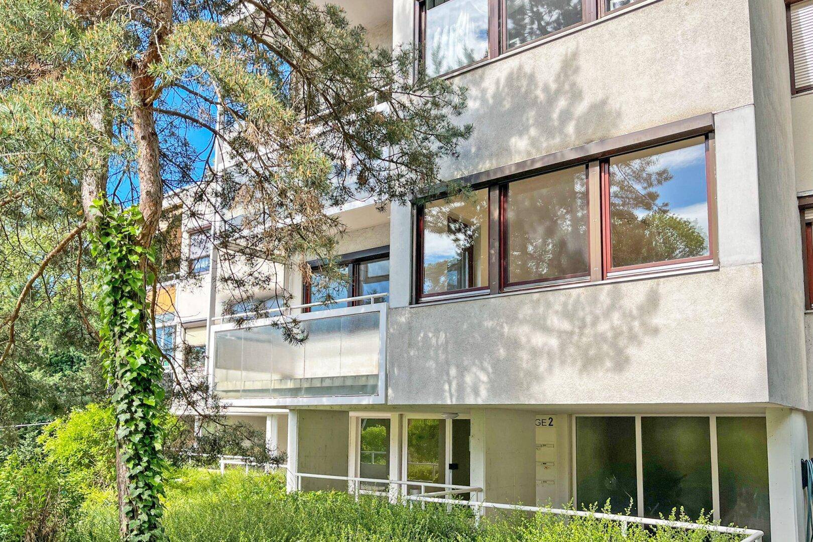Fassade eines Mehrfamilienhauses mit Balkonen und einem barrierefreien Zugang über eine Rampe.