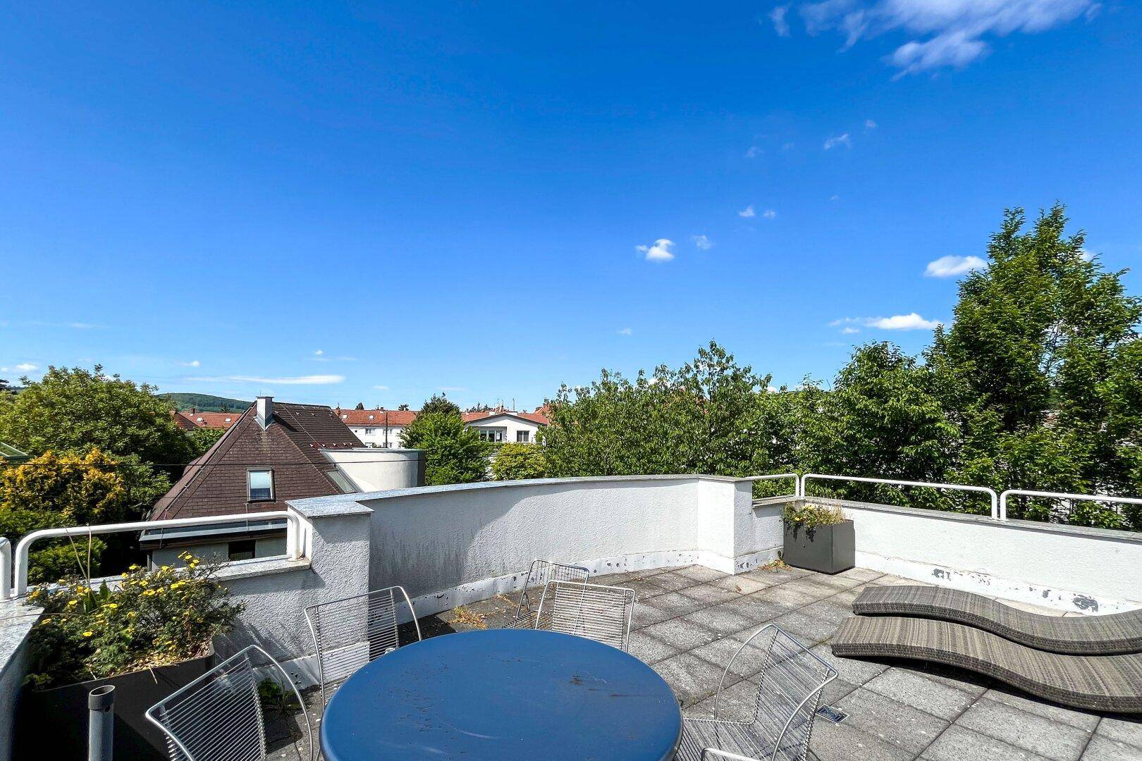 Geräumige Dachterrasse mit Sitzgelegenheiten und weitem Blick über die Umgebung.
