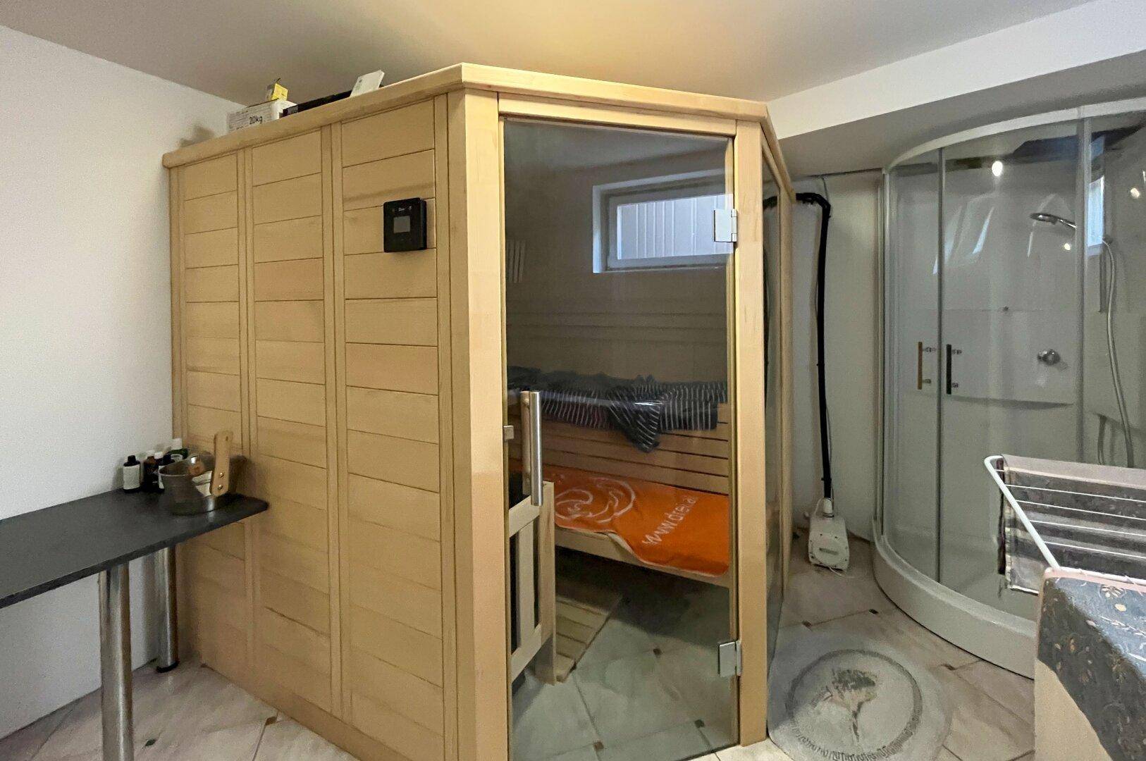 Badezimmer mit integrierter Sauna und moderner Duschkabine für Entspannung.