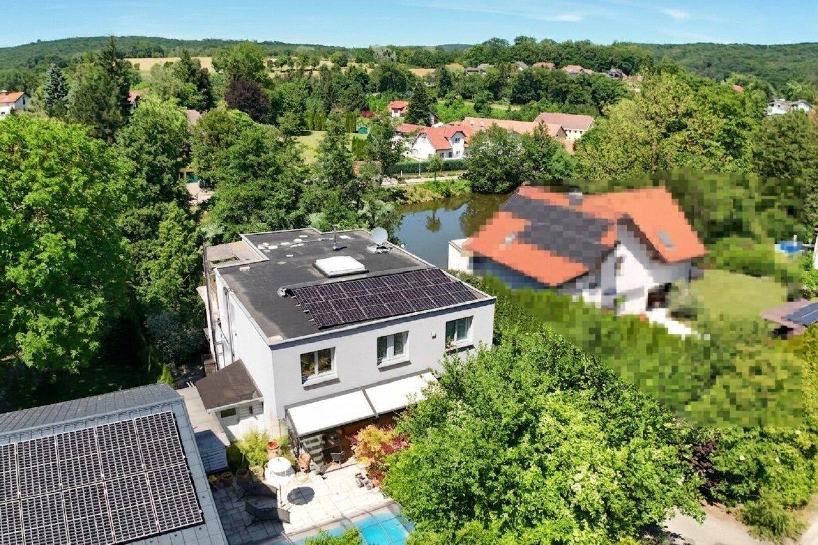 Luftaufnahme des Hauses mit Garten, Pool und Blick auf den See und die umliegende Landschaft.
