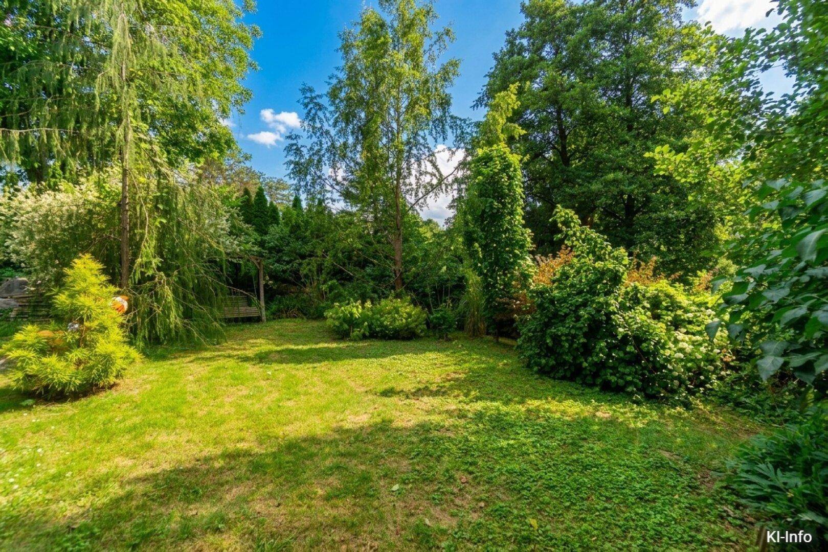 Gepflegter Garten mit Rasenfläche, hohen Bäumen und üppiger Vegetation.
