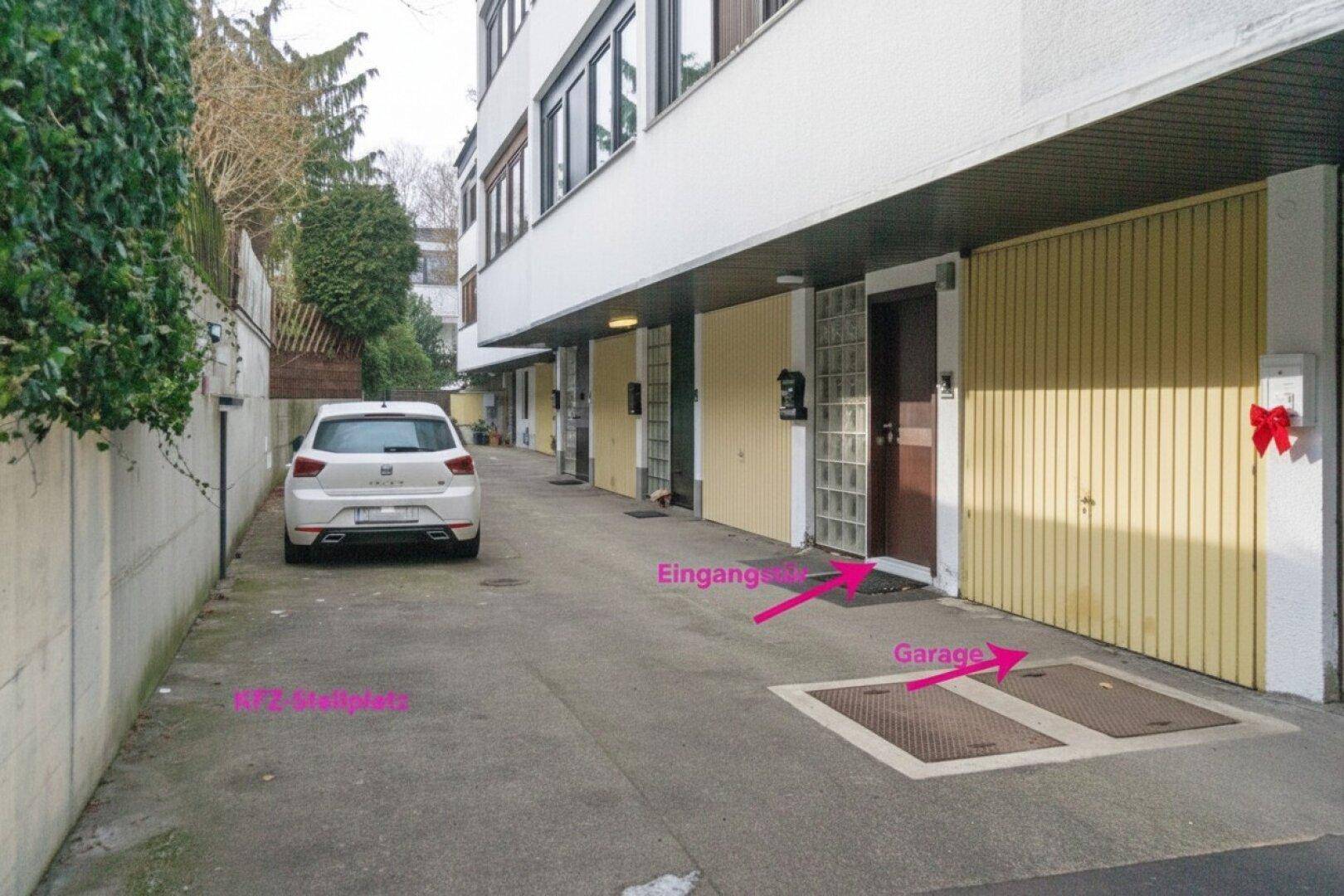 Reihe von Garagen und Eingangsbereichen mit einem Stellplatz für ein Fahrzeug auf dem Hof.