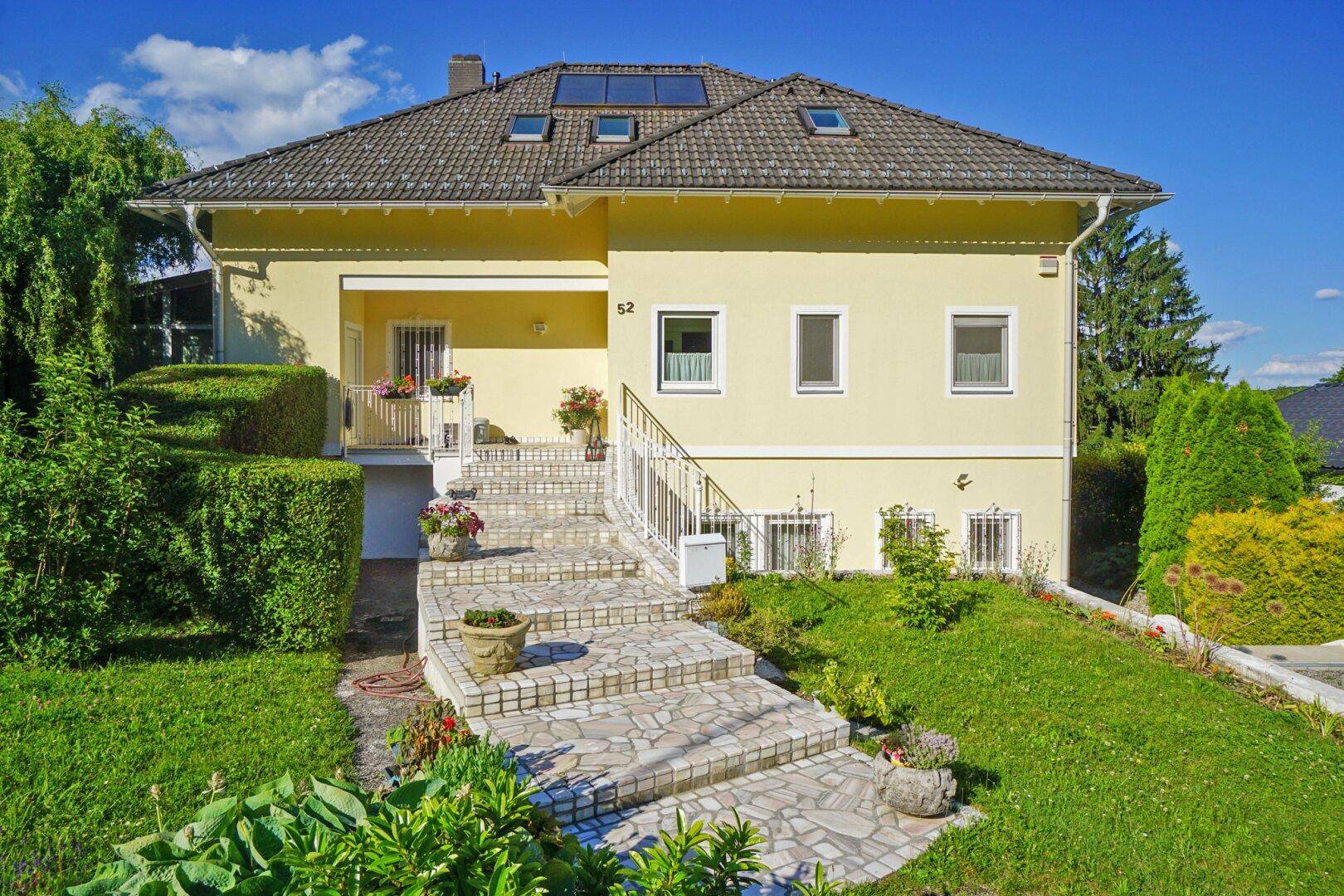 Charmante Hausfassade mit einladendem Eingangsbereich und gepflegter Steintreppe.