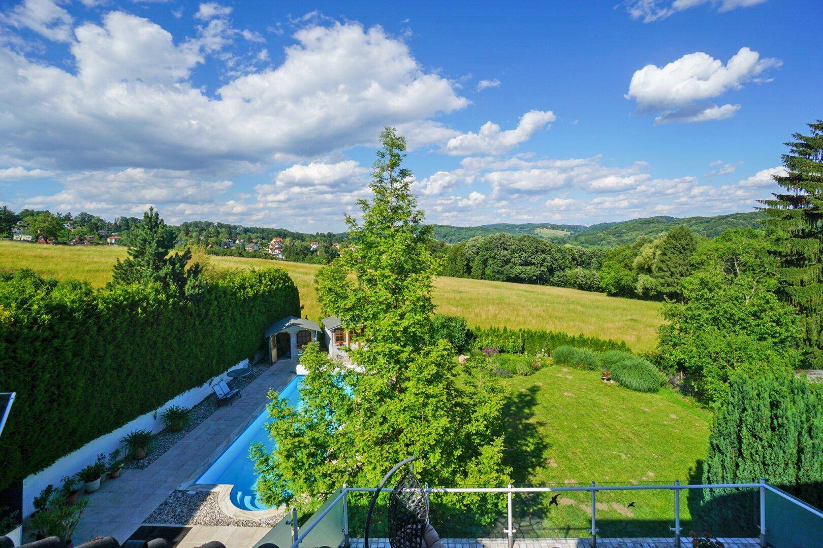Weitläufiger Panoramablick über den gepflegten Garten und die umliegende grüne Landschaft.