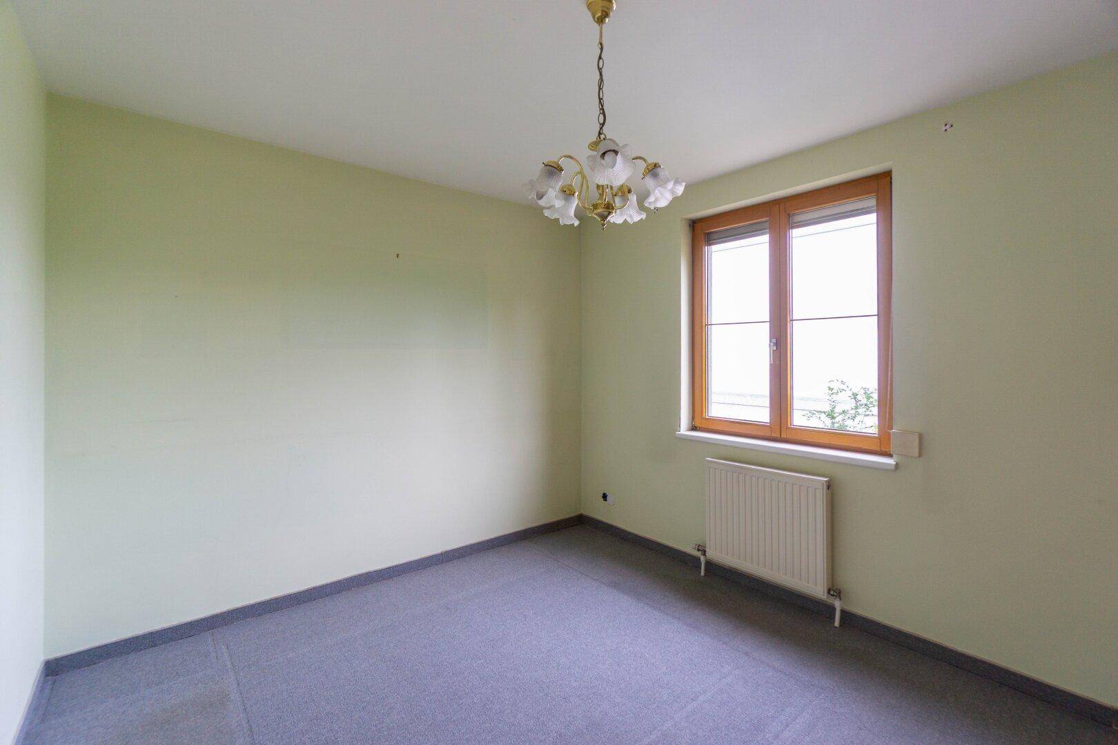 Ruhiges Schlafzimmer mit Teppichboden und Fenster, bietet eine angenehme Atmosphäre.