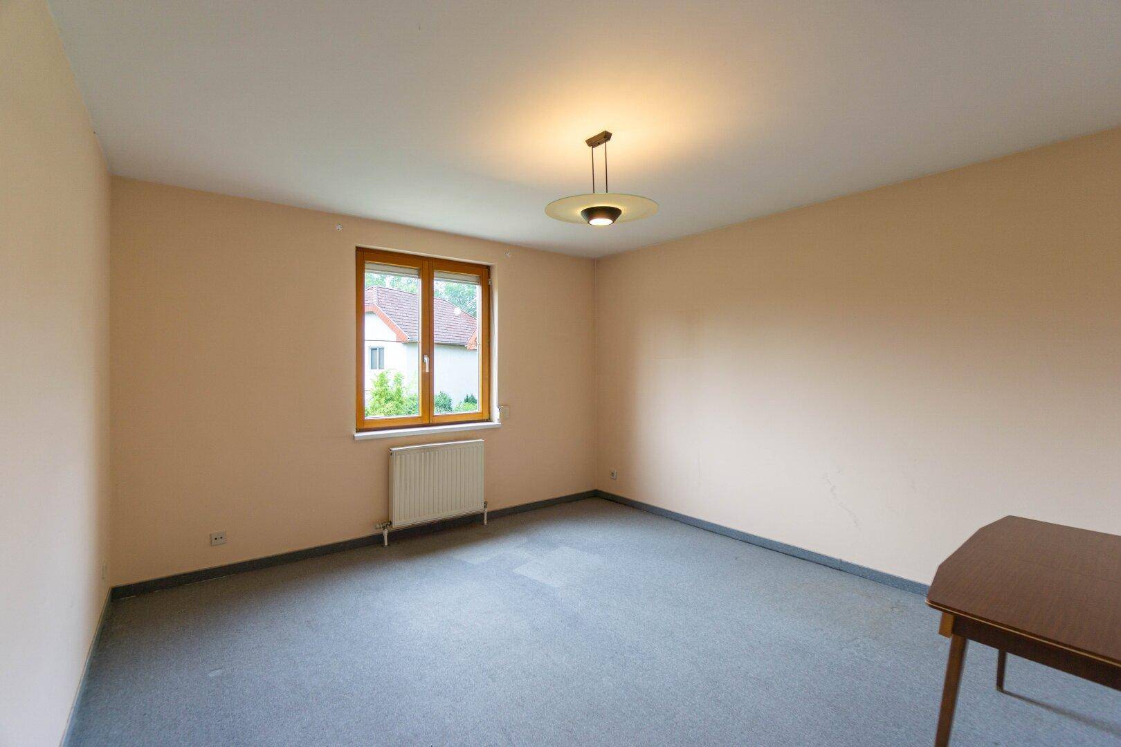 Geräumiges Schlafzimmer mit Teppichboden und Fenster, ideal für individuelle Einrichtungsideen.