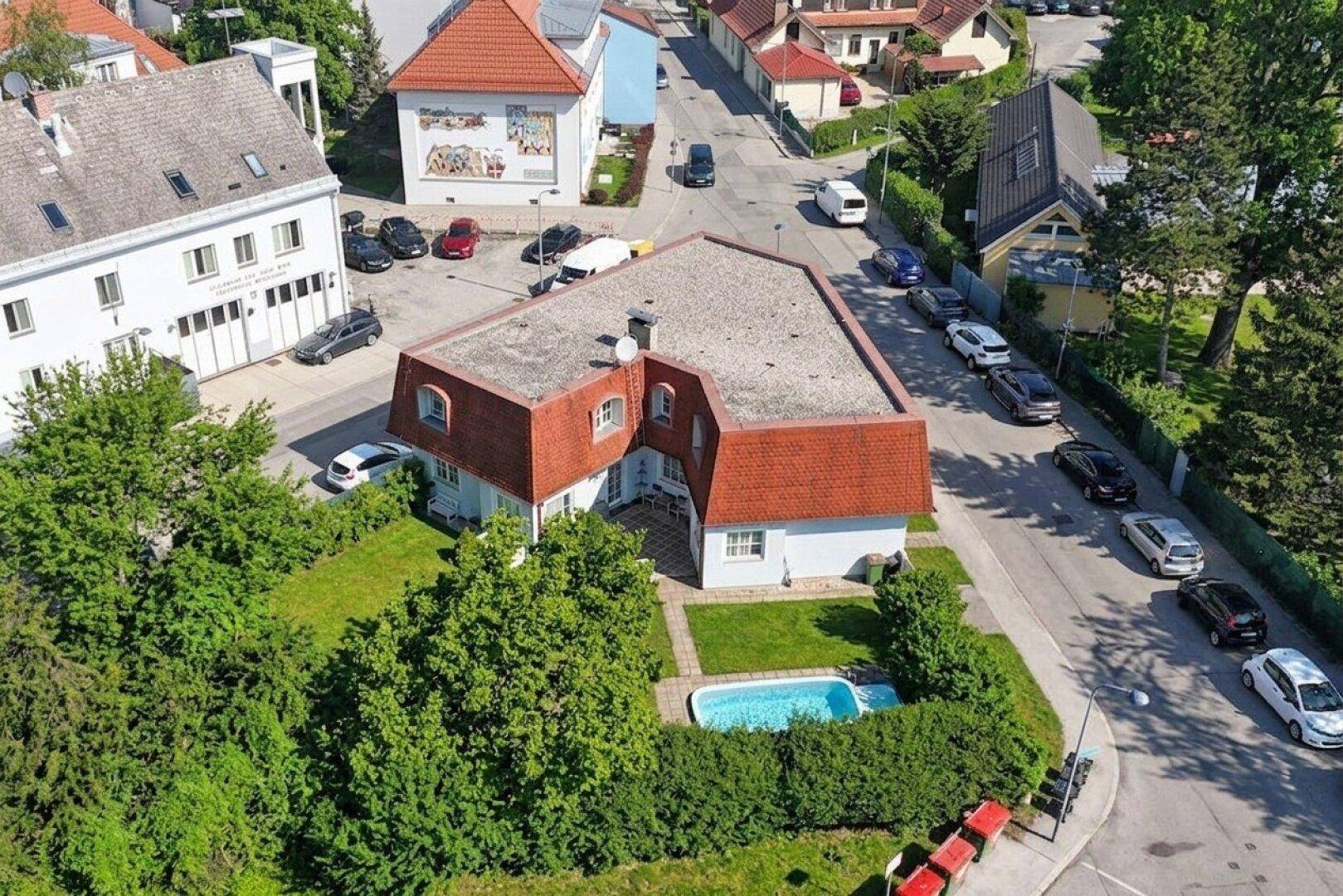 Luftaufnahme des Anwesens mit Haus, Garten und einem kleinen Swimmingpool.