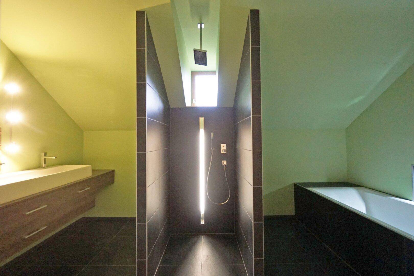Modernes Badezimmer mit begehbarer Dusche, Badewanne und Doppelwaschbecken unter Dachschräge.