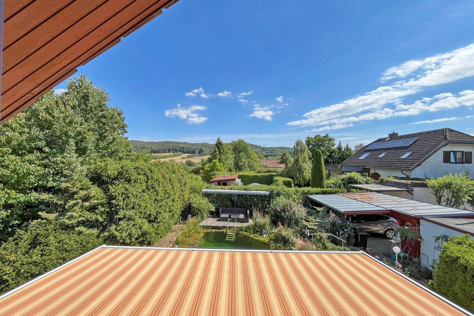 Weitläufiger Blick über die grüne Landschaft, Gärten und Dächer der Nachbarschaft.