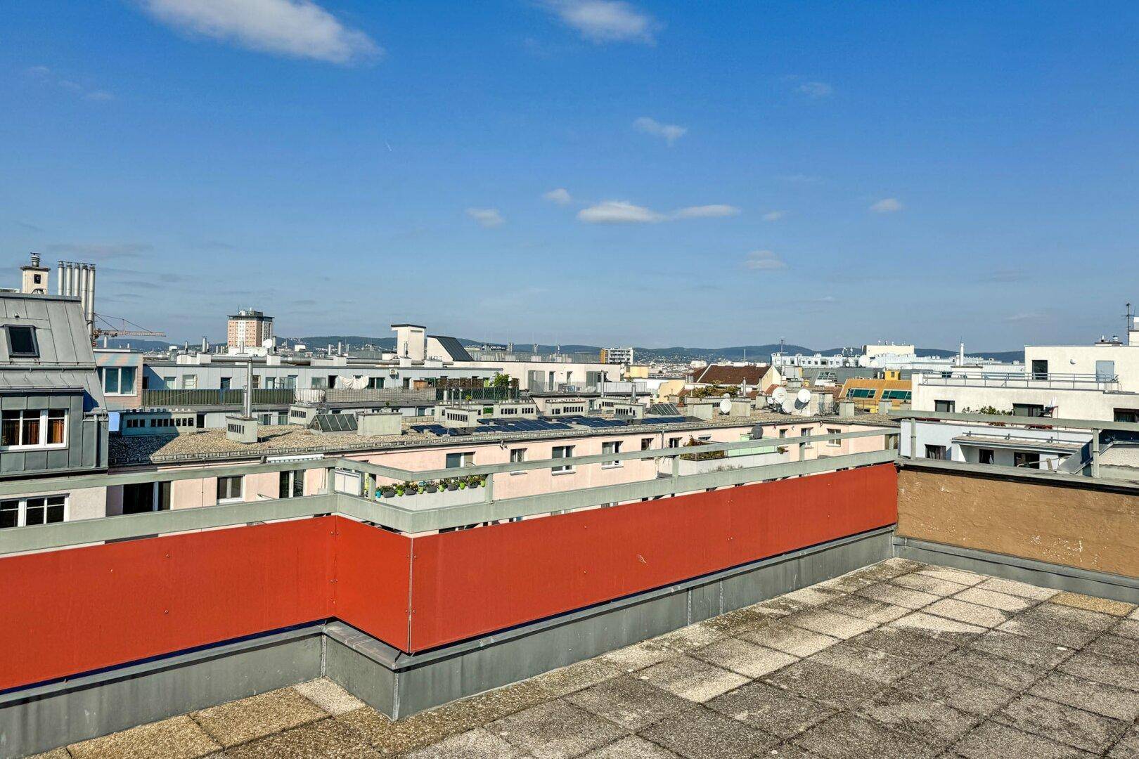 Panoramablick über die Dächer der Stadt von einer weitläufigen Dachterrasse.