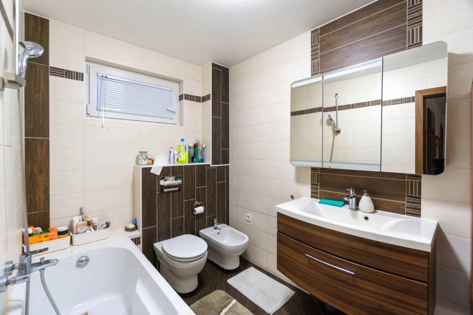 Geräumiges Badezimmer mit Badewanne, WC, Bidet und großem Spiegelschrank.