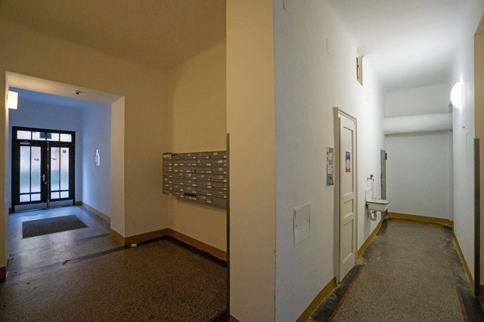 Eingangsbereich eines Mehrfamilienhauses mit Briefkästen und Zugang zu weiteren Fluren.