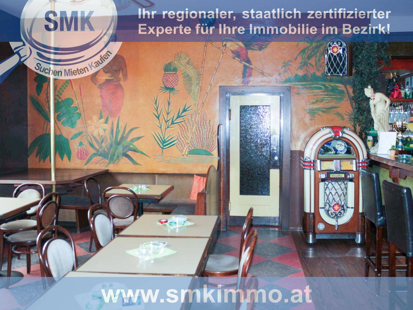 Innenraum eines Lokals mit Tischen, Bar, Jukebox und einer Wandmalerei im tropischen Stil.