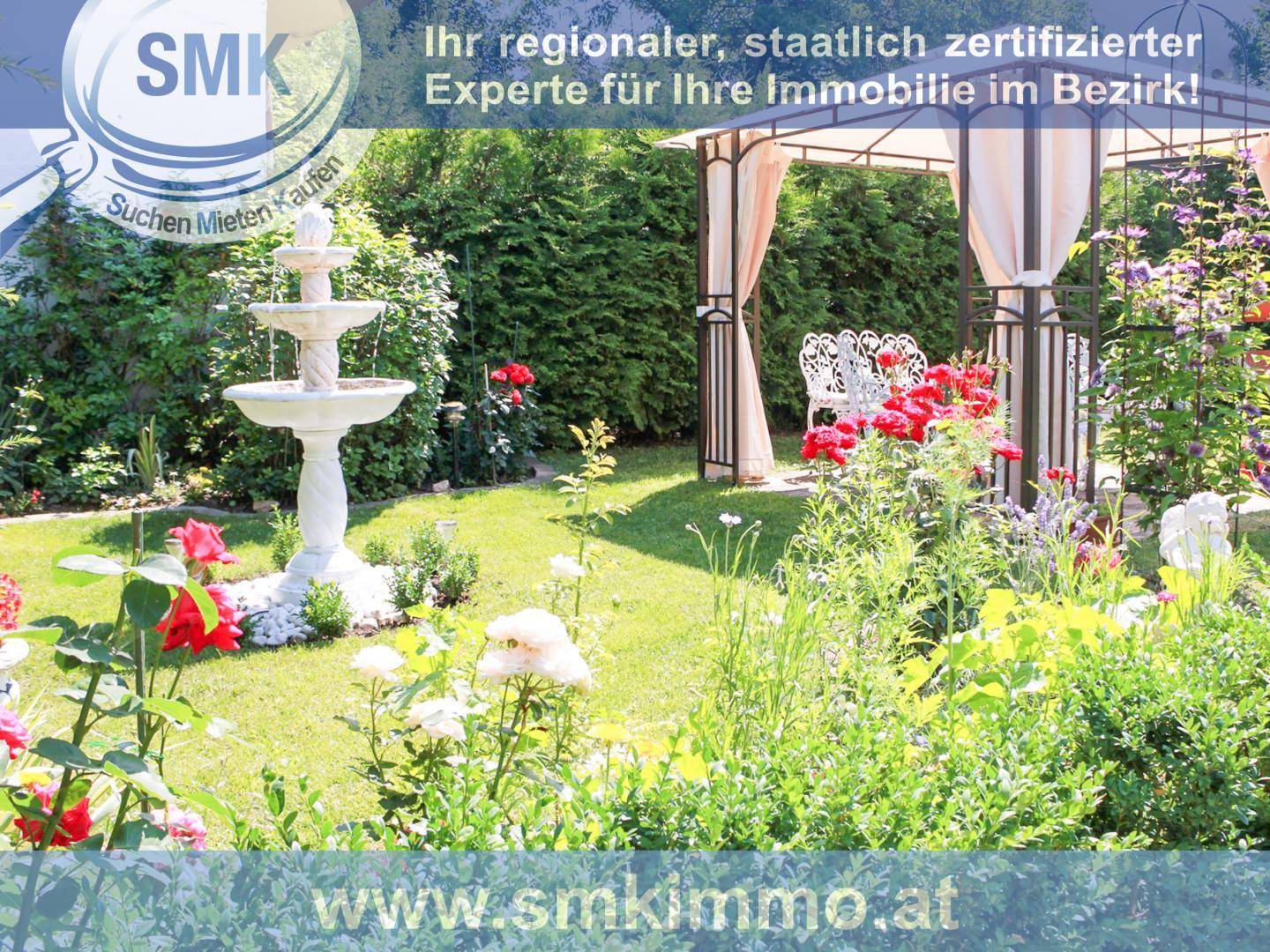 Gepflegter Garten mit einem dekorativen Brunnen, Blumenbeeten und einem Pavillon.