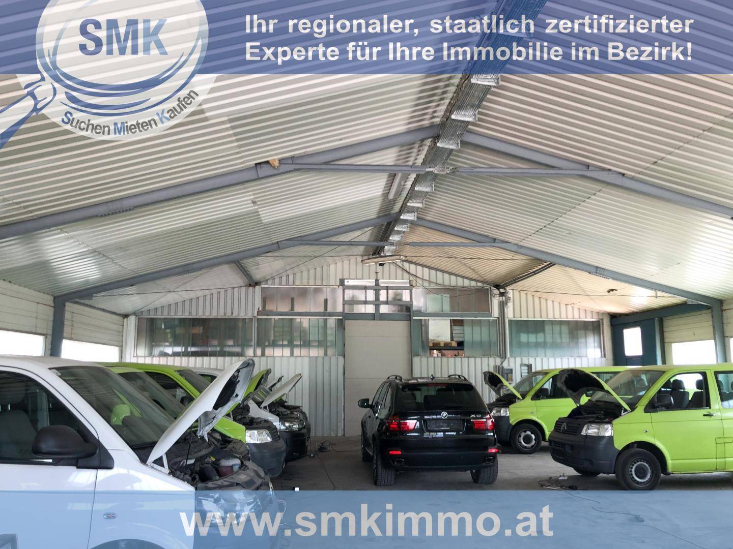 Innenansicht einer Werkstatt oder Lagerhalle mit mehreren Fahrzeugen und Wellblechdach.